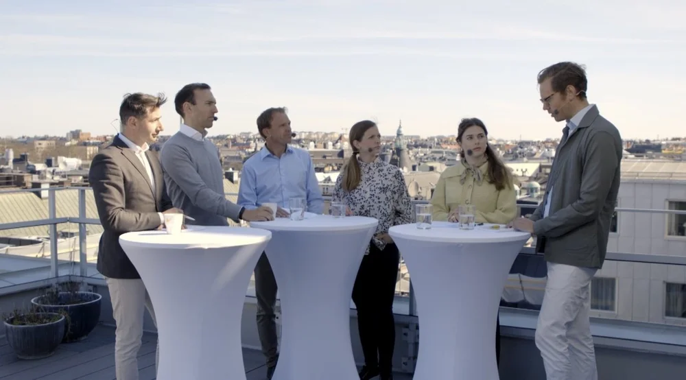 Guests at standing tables on a rooftop terrace during an event