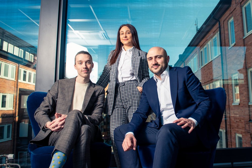 Management team in suits photographed by a window