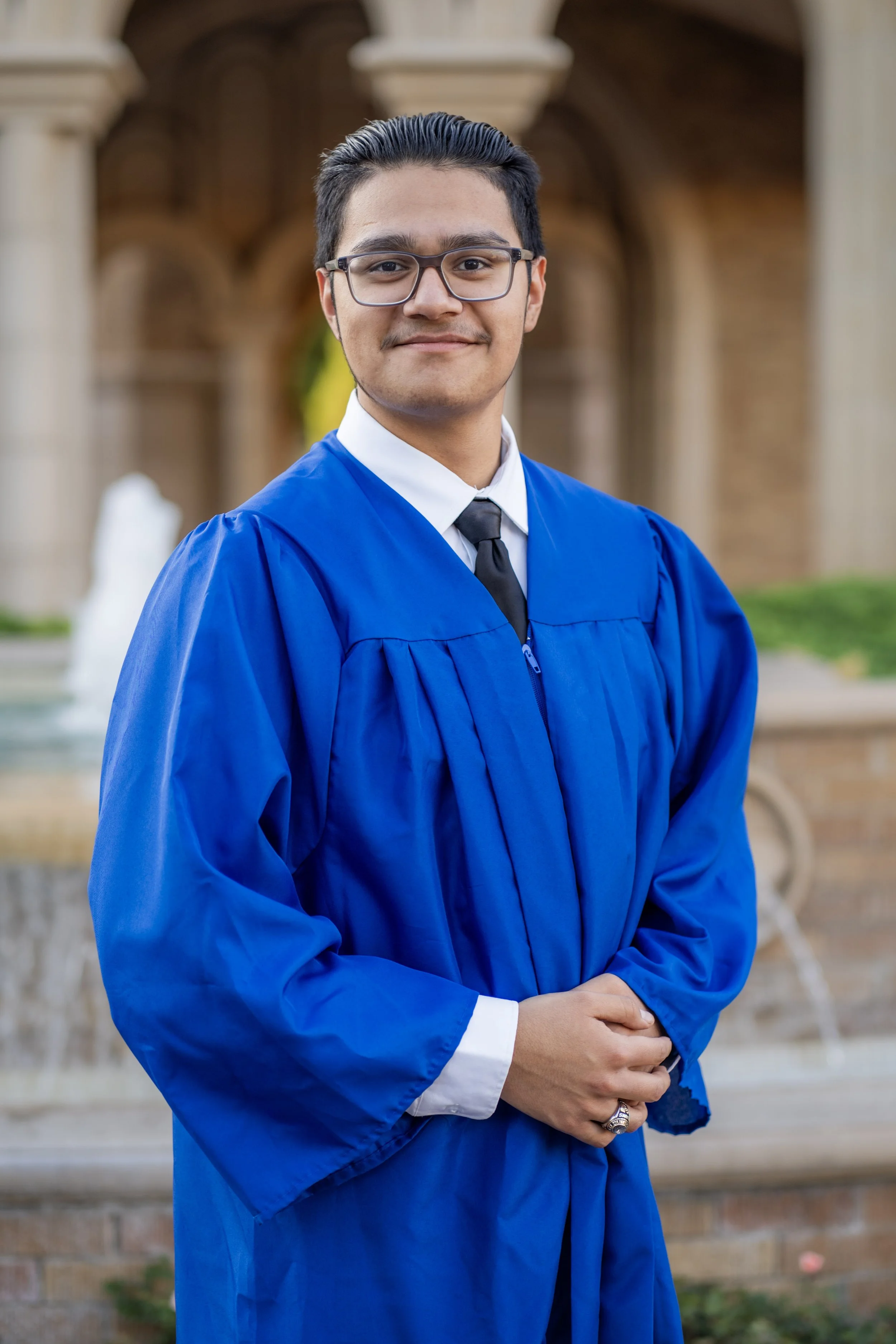 Senior photography in Amarillo Texas featuring a graduate in a cap and gown portrait in an outdoor architectural setting