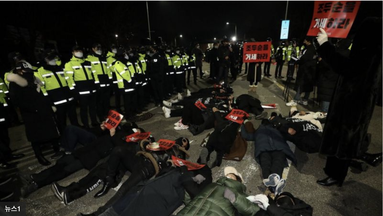 People laid their bodies down on the road in front of the vehicle to block Cho’s travel back to his place.