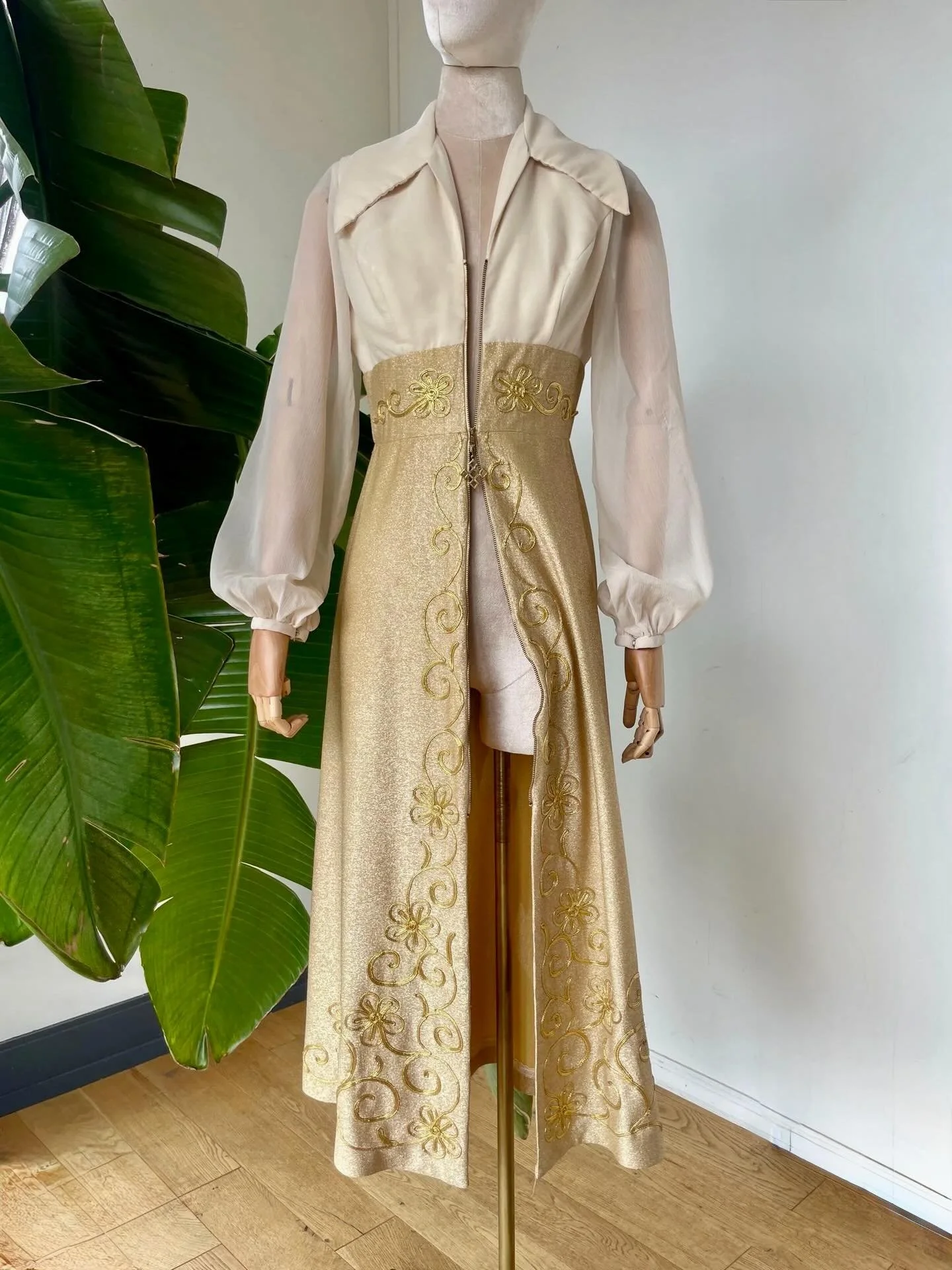 Gone by not forgotten! 
⠀⠀⠀⠀⠀⠀⠀⠀⠀
Breathtaking 1970s zip-up gown with exaggerated collar, semi-sheer peasant sleeves, and luxurious hand-sewn bonnaz detailing adorned across the waistband and around the full glittered skirt. Such a special piece with