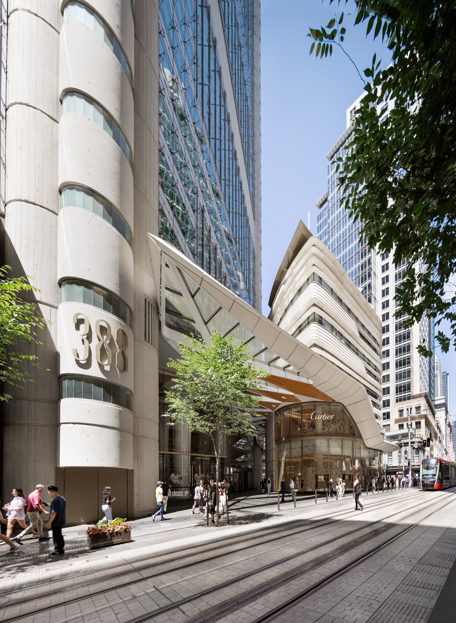 Street view of a modern building with a Cartier store at the base, busy pedestrian sidewalk, tram tracks, and high-rise buildings in a city setting. Designed by fjcStudio Photo by Ruth Gold