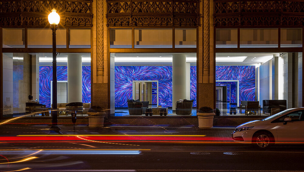 The exterior of the building features floor to ceiling LED walls with colorful abstract video loops.