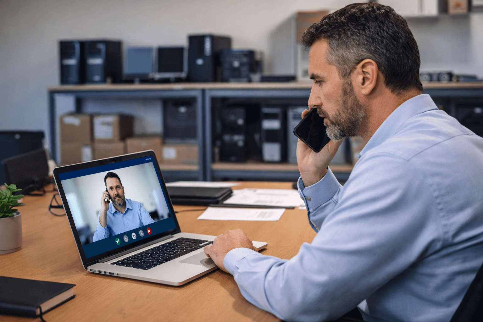 IT manager on a video call with a vendor while reviewing company laptops as part of hardware asset management