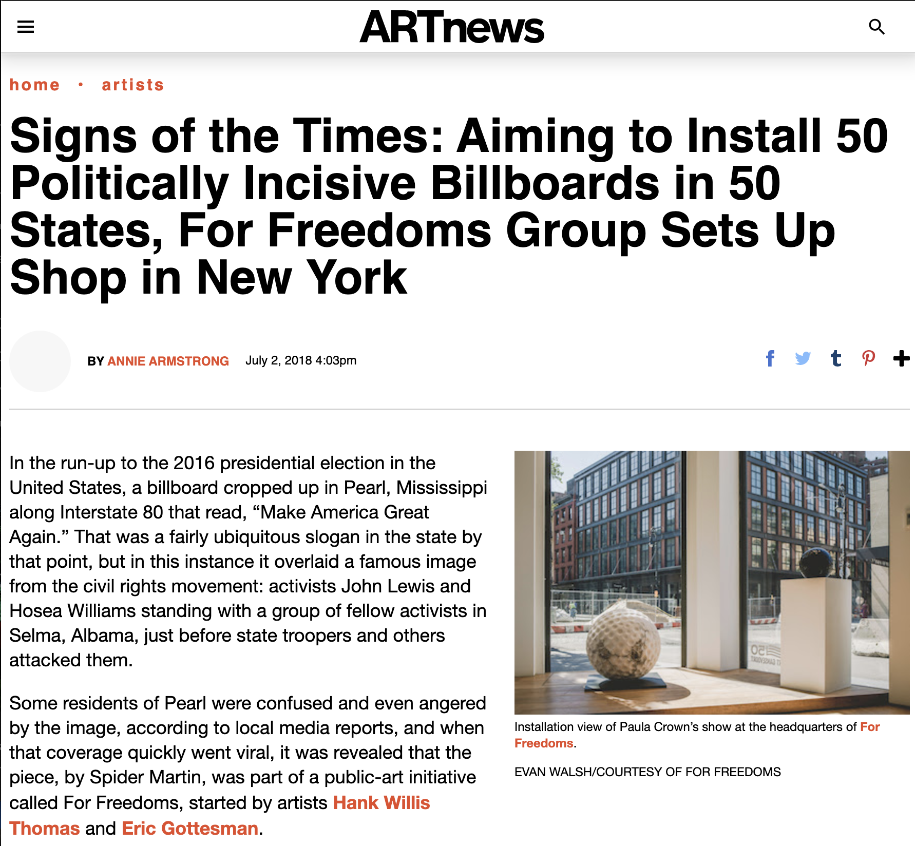 Interior view of art gallery showing sculptures, including large textured spherical art piece and a black sphere on tall pedestals, with modern multi-story buildings visible through the large windows.