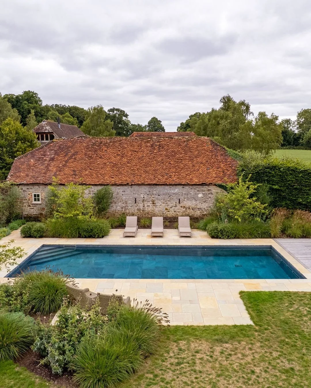 Today, we're longing for warm summer days. 🌞💦 

Nestled in the heart of Hampshire, this rural swimming pool offers a serene retreat, inviting you to unwind and soak in the warm sun. The inviting warmth and golden hues of Ruishton Weathered Riven Li