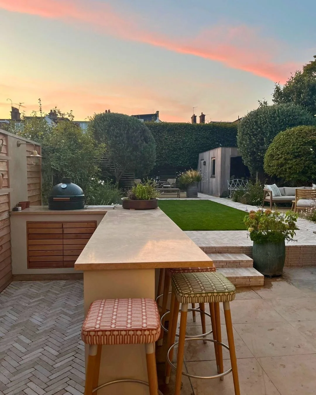 Let's end November on a high, with this stunning sunset casting a radiant glow over this  charming urban garden. The sky adds a soft orange tone to the space, complementing the warm tones of Zahra Beige Stackers and kitchen worktop, creating a serene