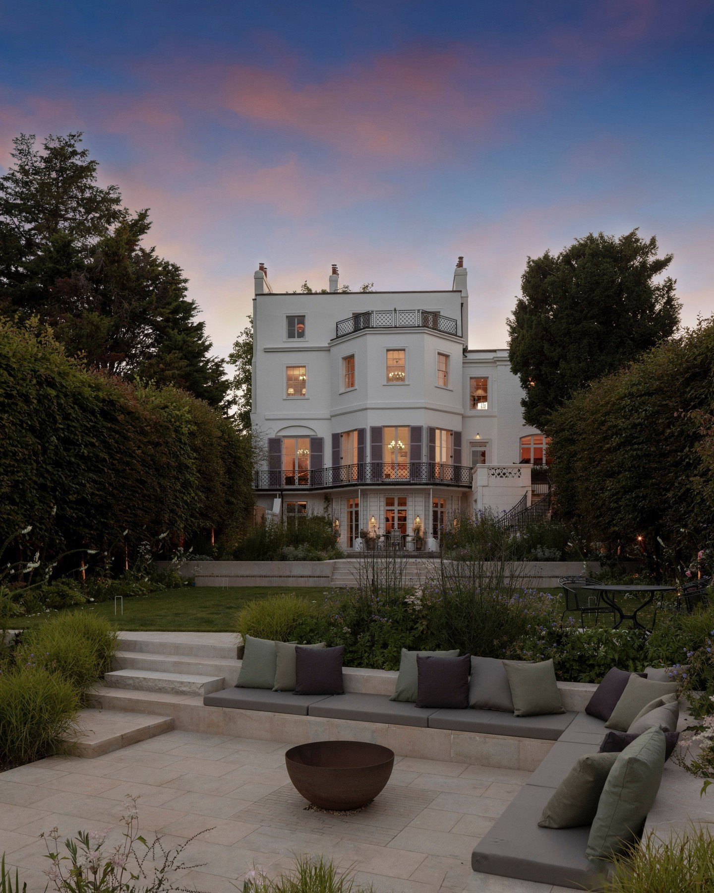 A glorious evening shot of Ryan House in Twickenham, a Grade II listed Georgian building from the early 19th century that was recently restored. 

As part of its renovation, we supplied Bianca Flamed paving to elevate the riverside garden, creating a