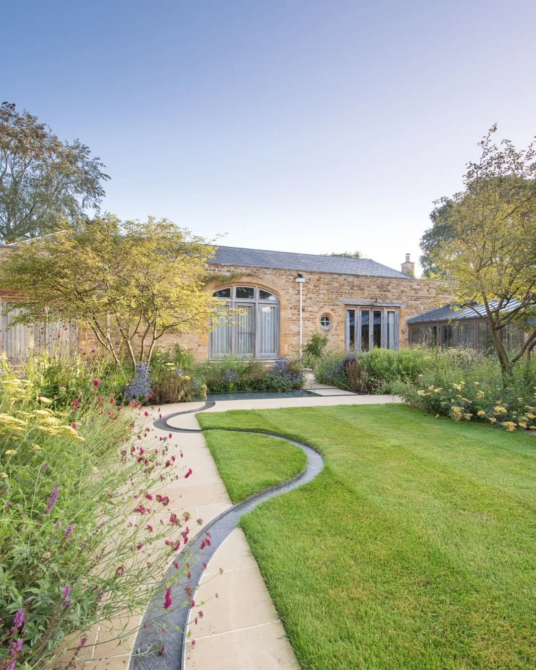 This stunning garden beautifully combines both modern and rustic designs, creating a serene atmosphere 🌿

Our Darley Worn Yorkshire Sandstone paving adds a warm tone to the garden, complementing the warm tones of the building&rsquo;s bricks. Meanwhi
