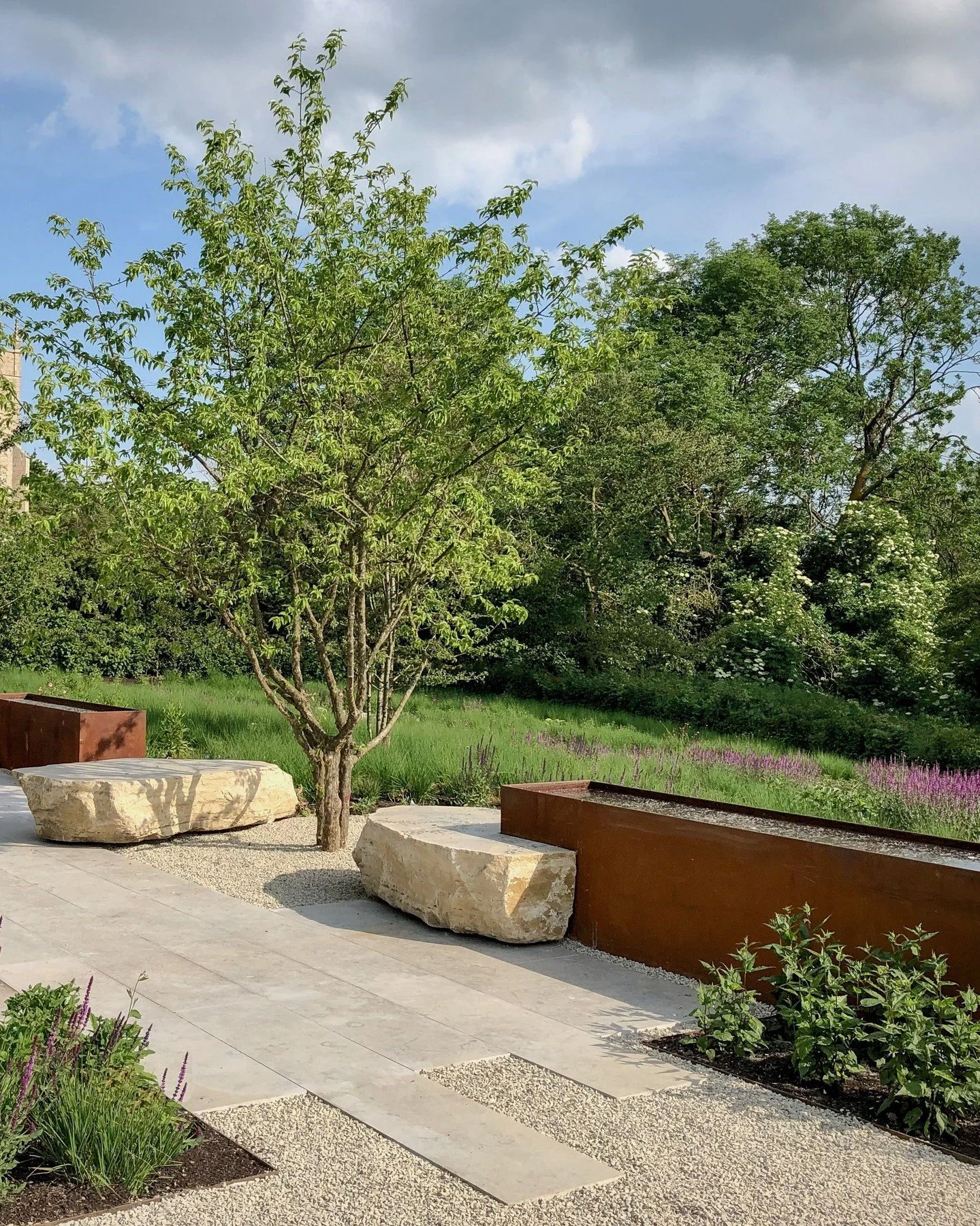 This beautiful garden in Cambridgeshire features Langton Feature Stones with a sawn top, making them ideal for a reading spot or a relaxing seat to enjoy the sunshine. ☀️ 

The creamy pale beige tone of these Purbeck Boulders complements the Royal Mi