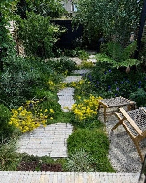 Nestled in North East London, this urban garden is a true oasis of color and peace. 

Vibrant flowers and lush plants burst with life, harmonising with Somerset Buff Selfbinda and the carefully arranged Luciano Stackers that form a charming stepping-