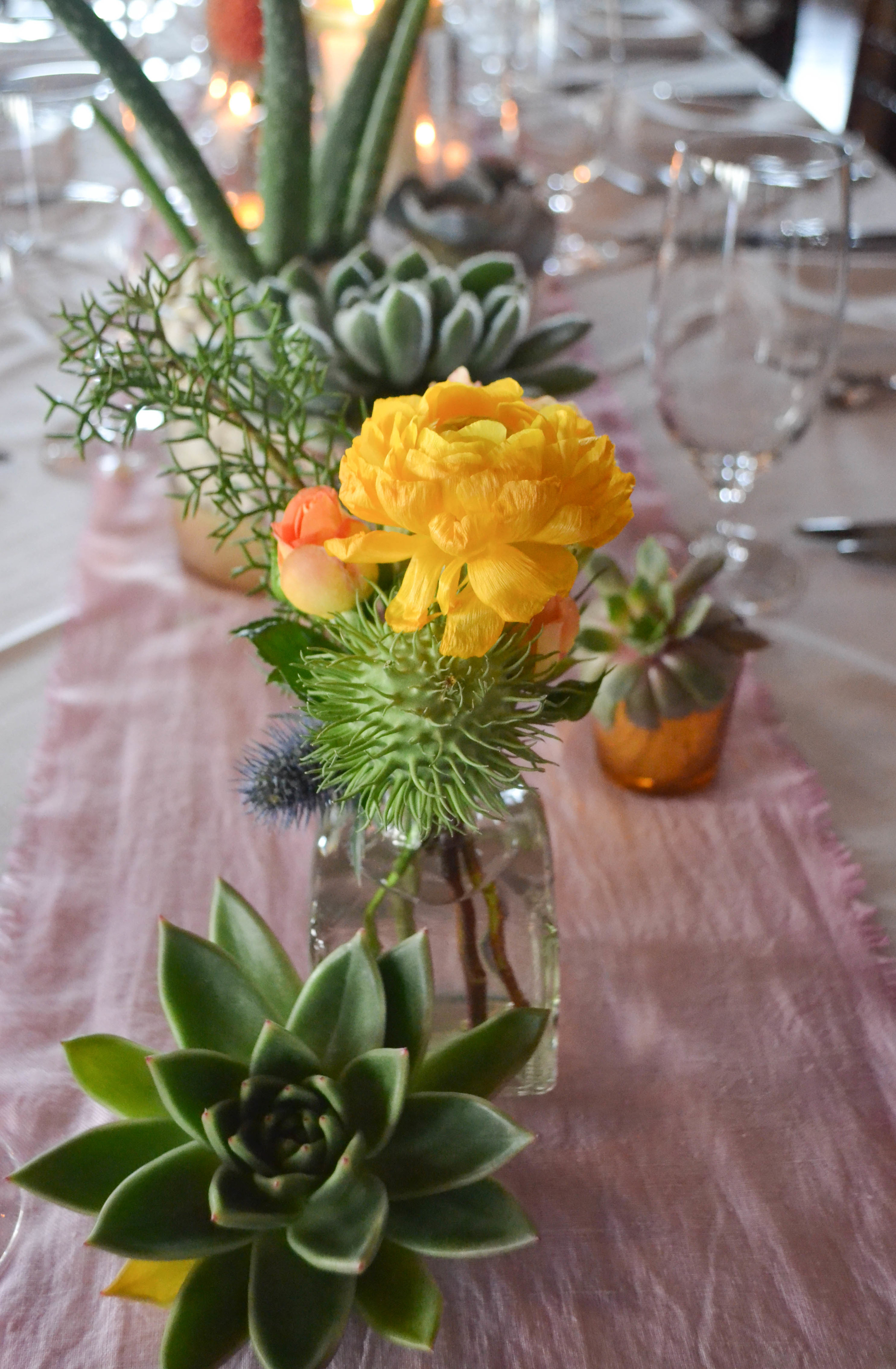 Liberty Warehouse Southwest Succulent Mexican weddingOrange, pink, white and slate blue centerpieces with succulents and candles.