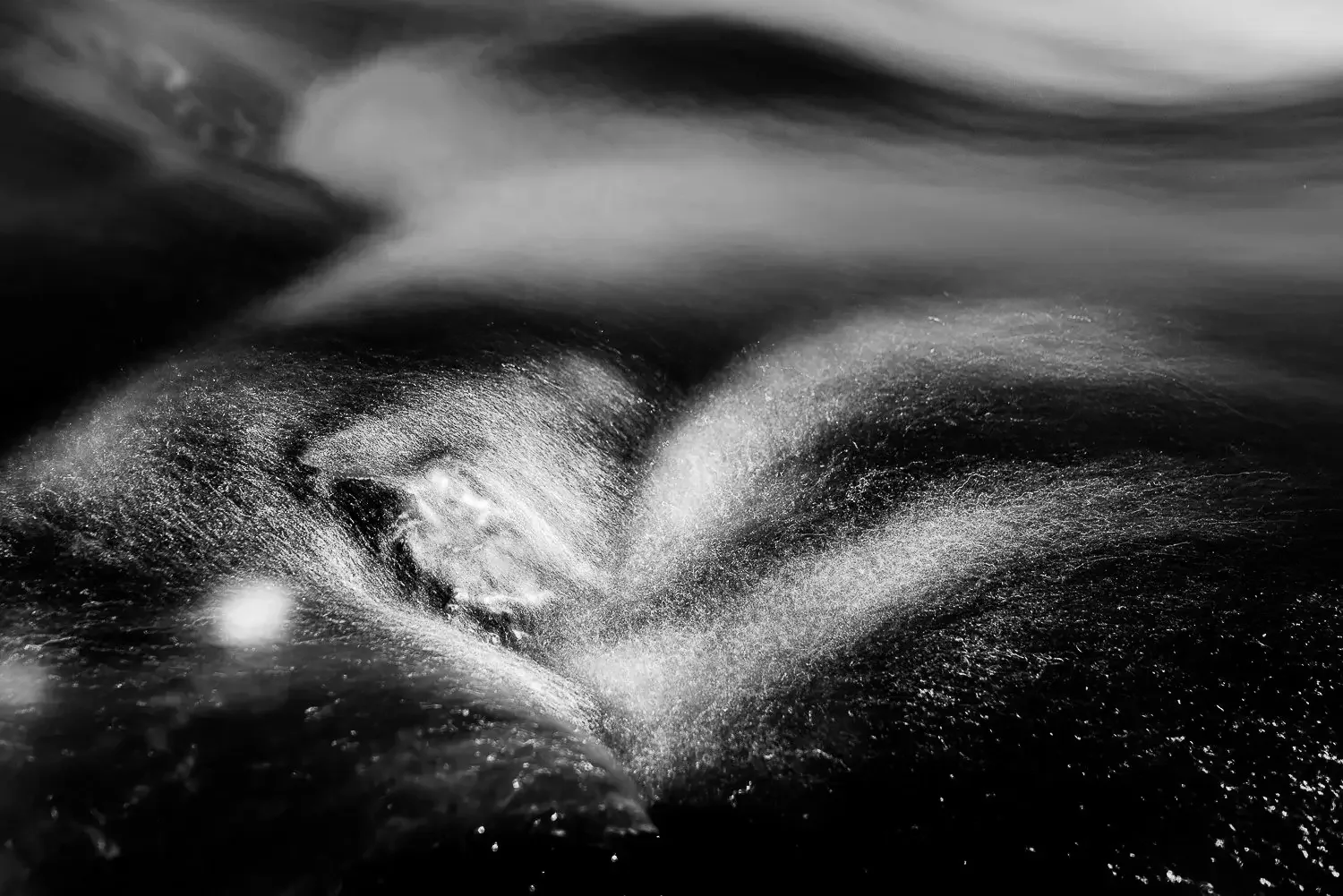 Abstract black and white photo capturing movement and texture, possibly of water or clouds in motion.