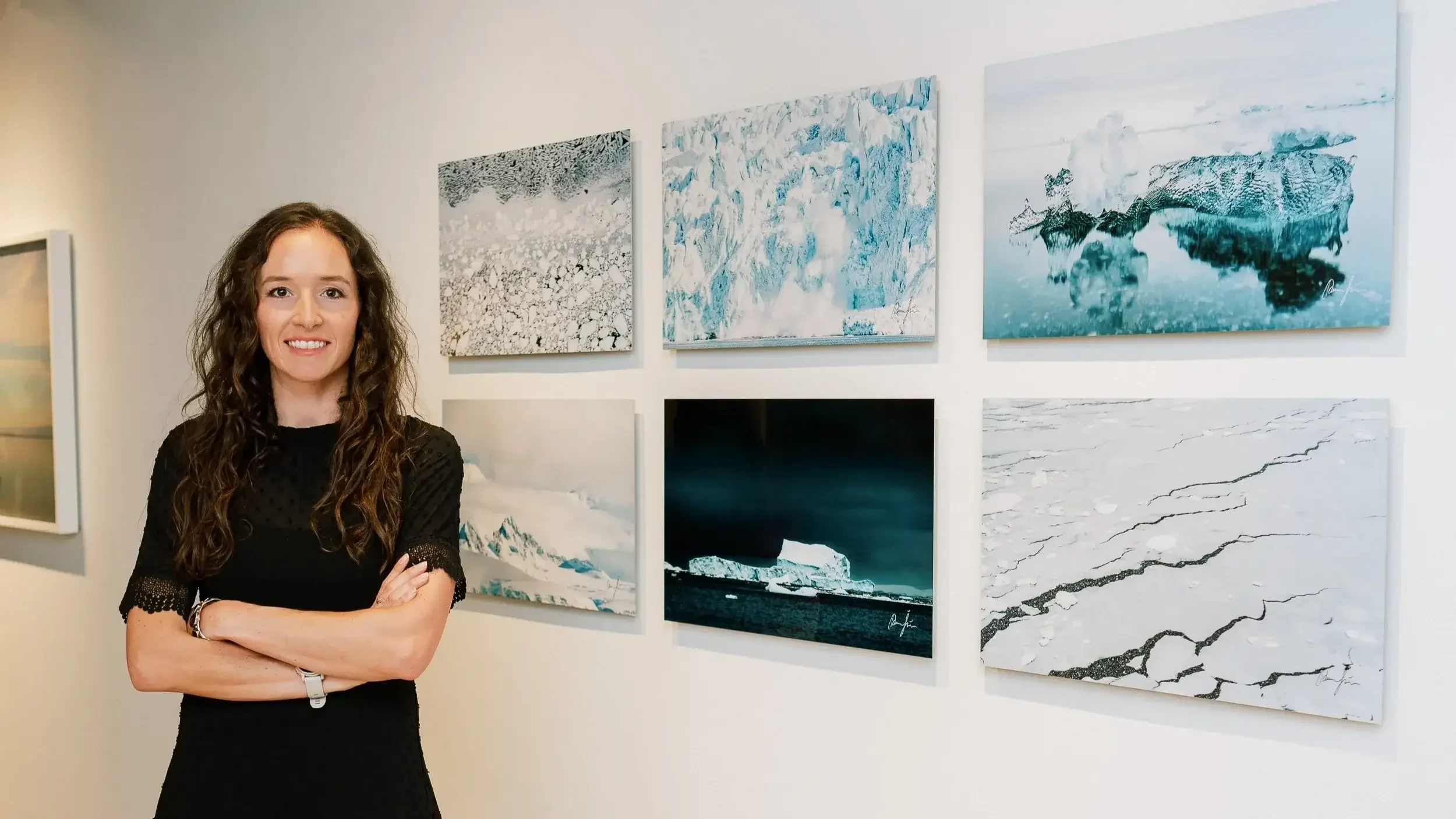 artist Tamara Susa in front of her photographs exhibited at the Red Brick gallery