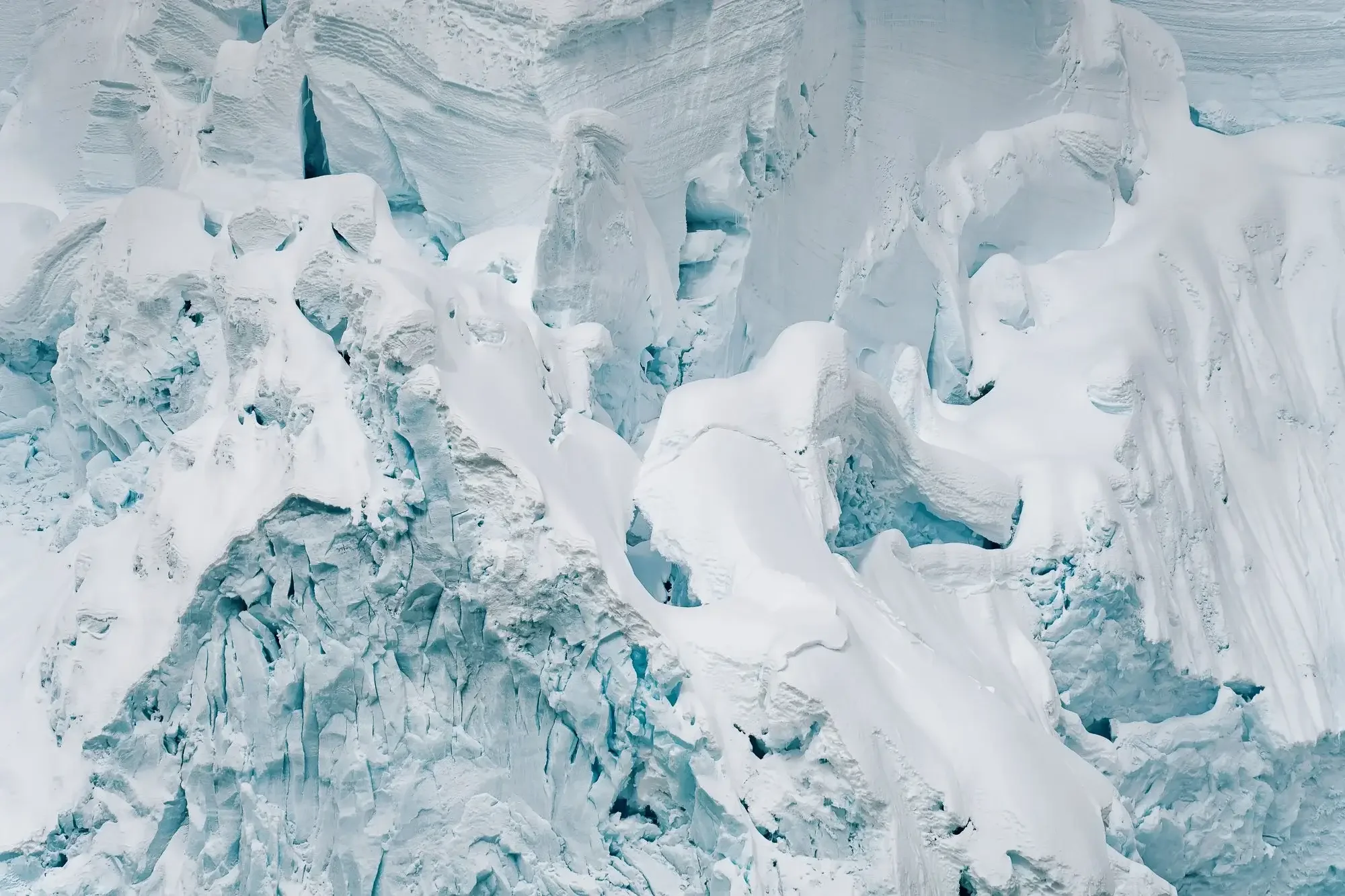 A glacier with jagged ice formations and snow covering the surface.