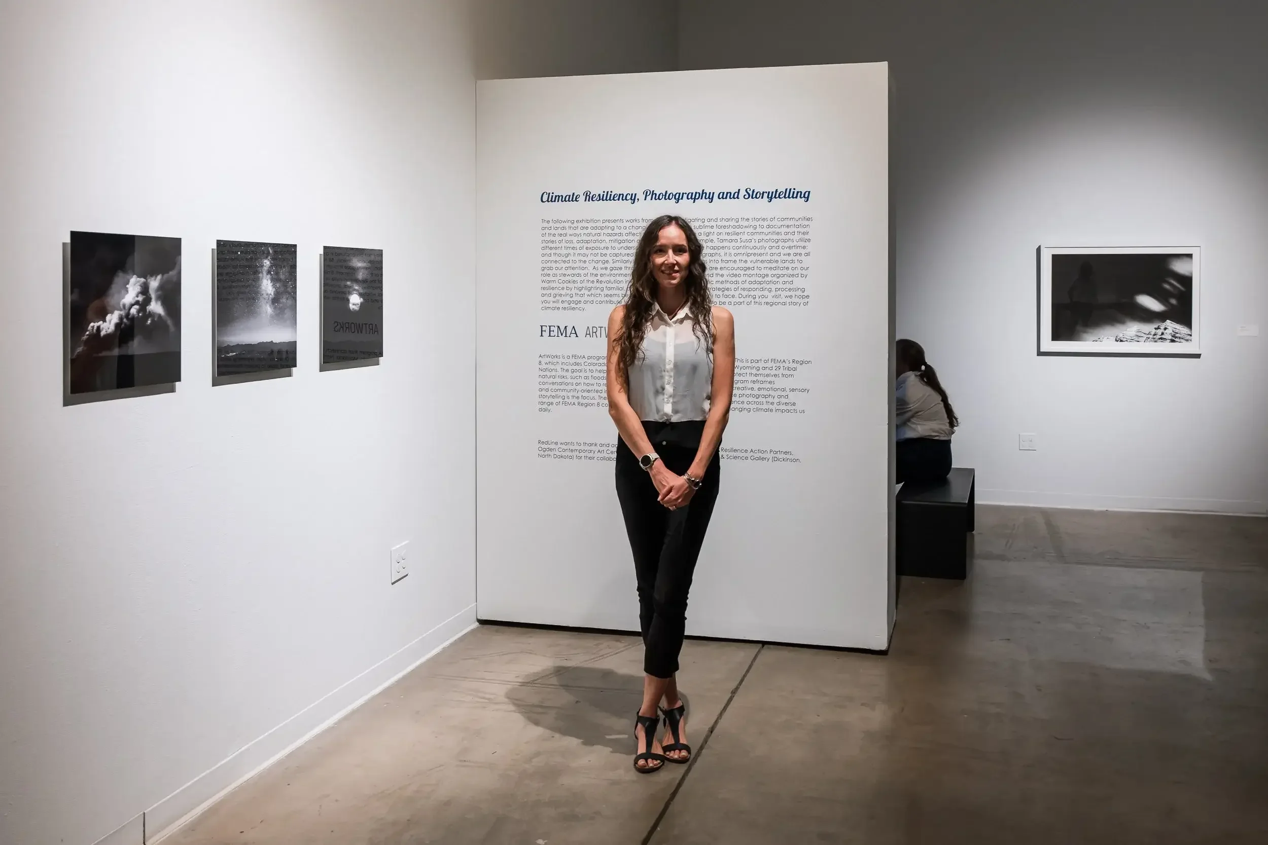 photographer tamara susa standing in front of her work in Redline Gallery in Denver
