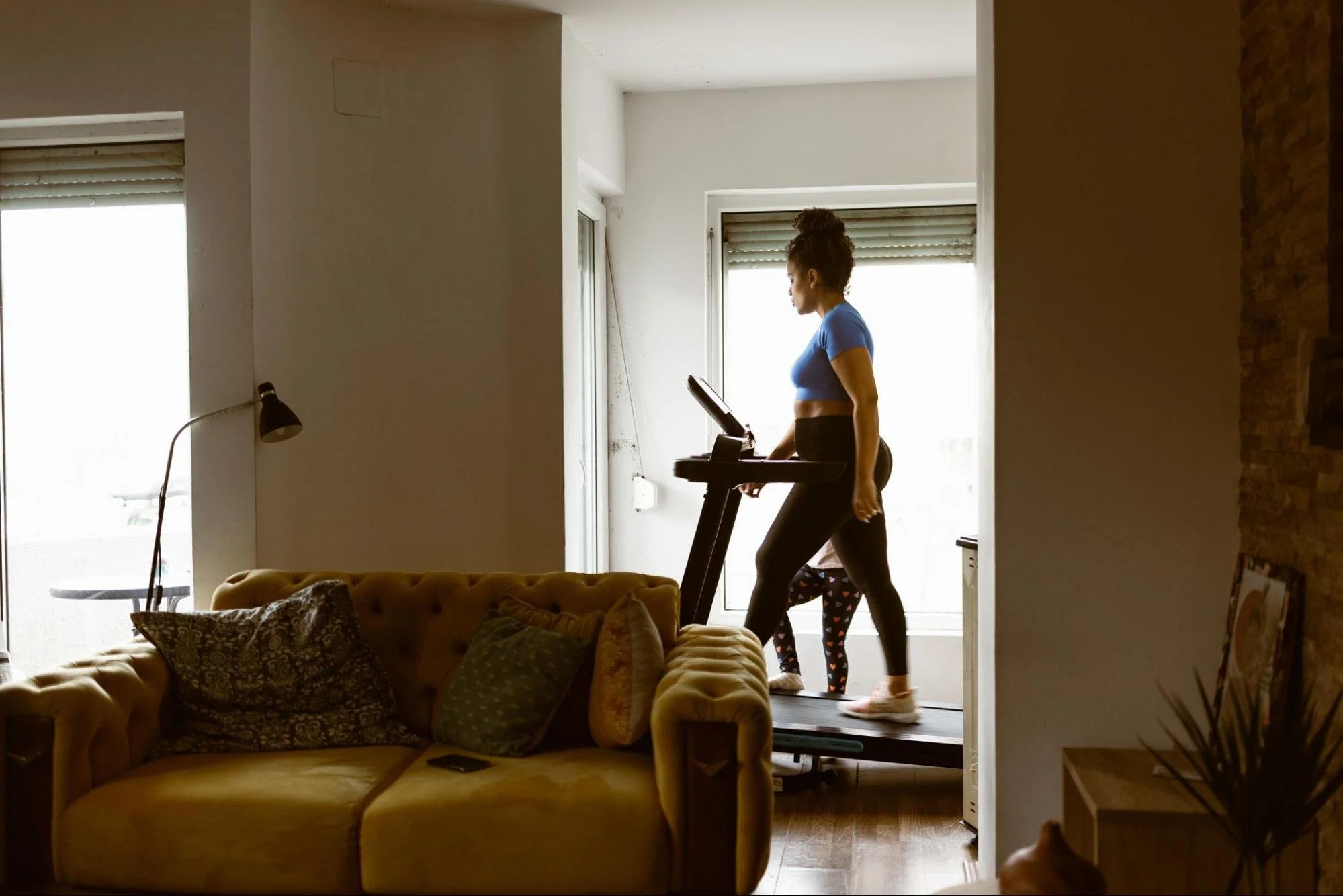 A woman using a treadmill in her home.