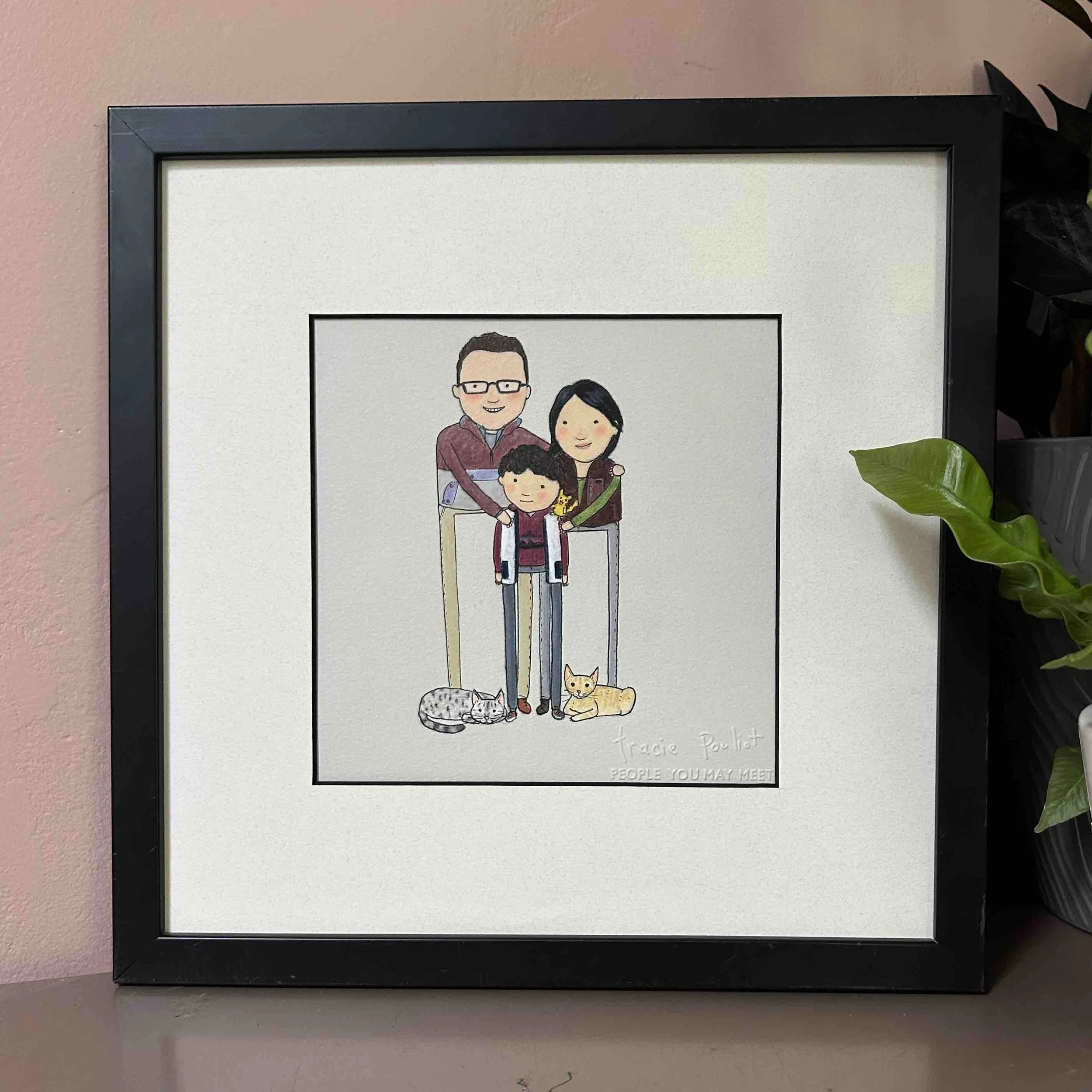 framed drawing of family of three and cats