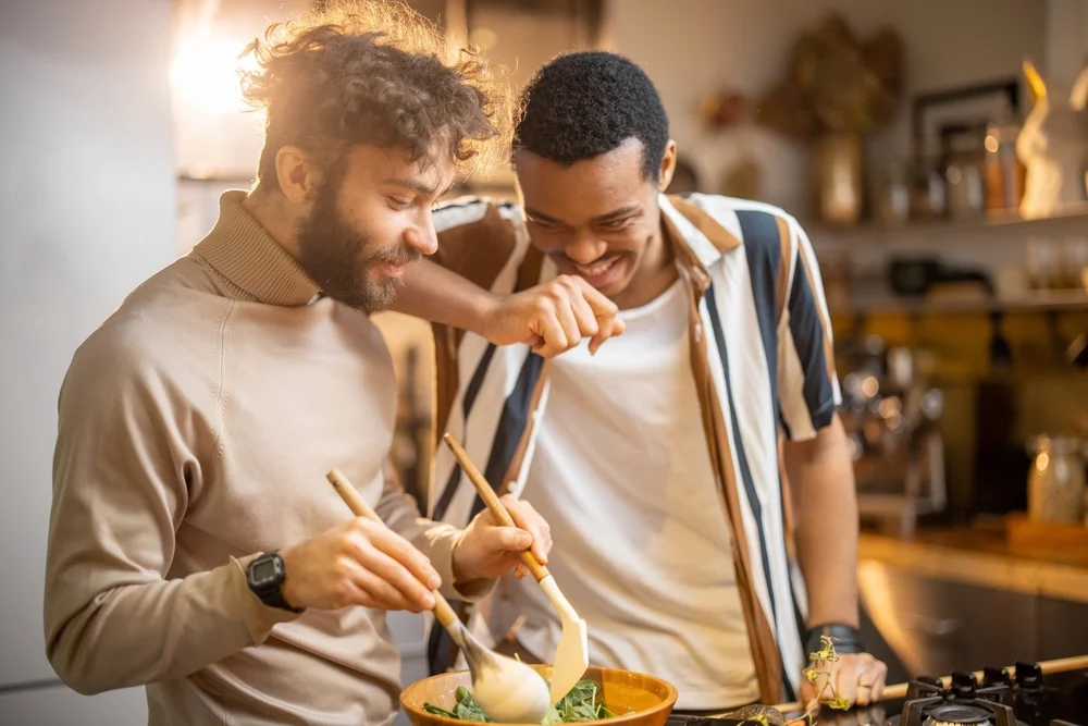 Two men cooking together at home