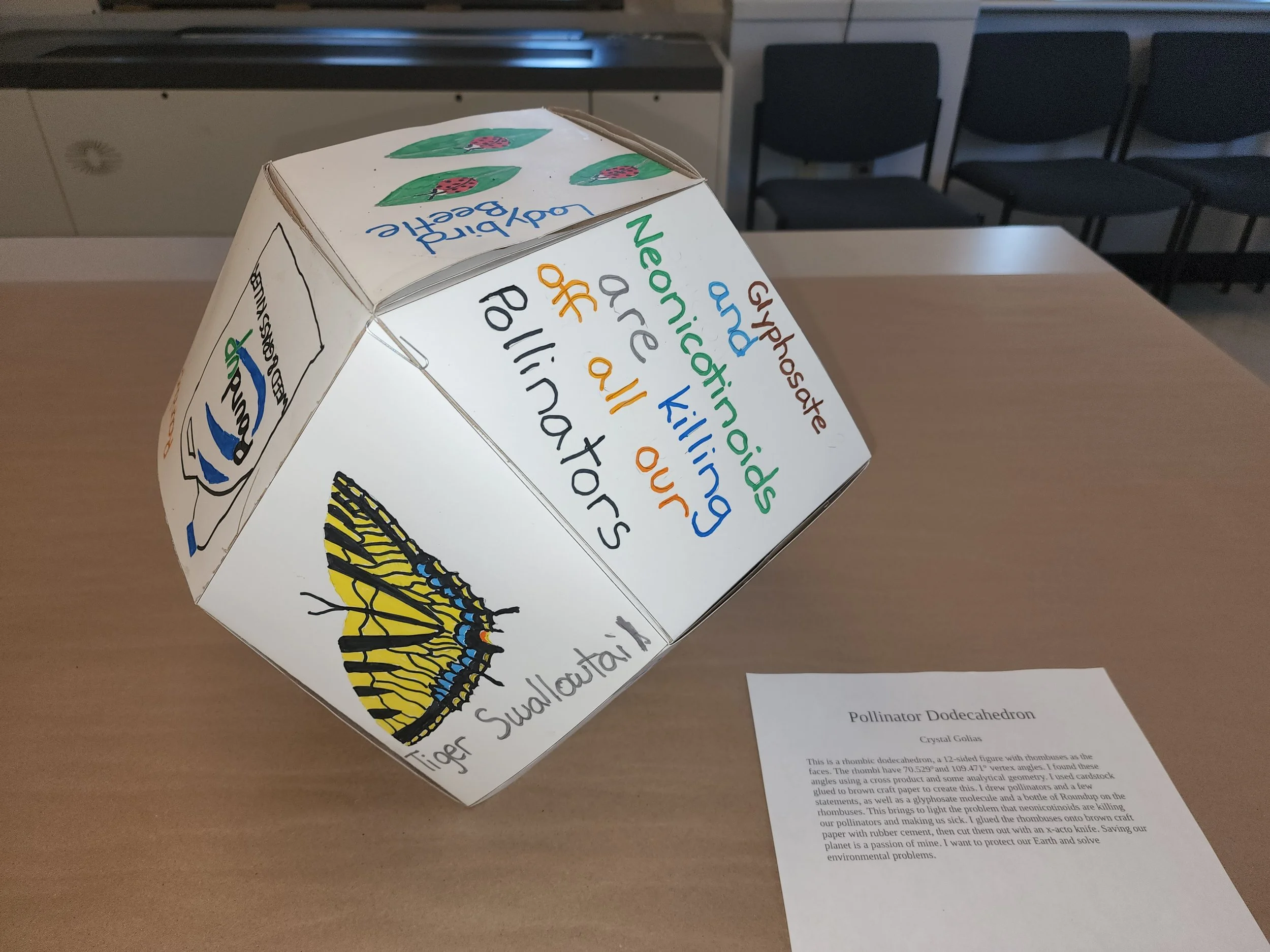 A large rhombic dodecahedron made by plaiting paper strips.
