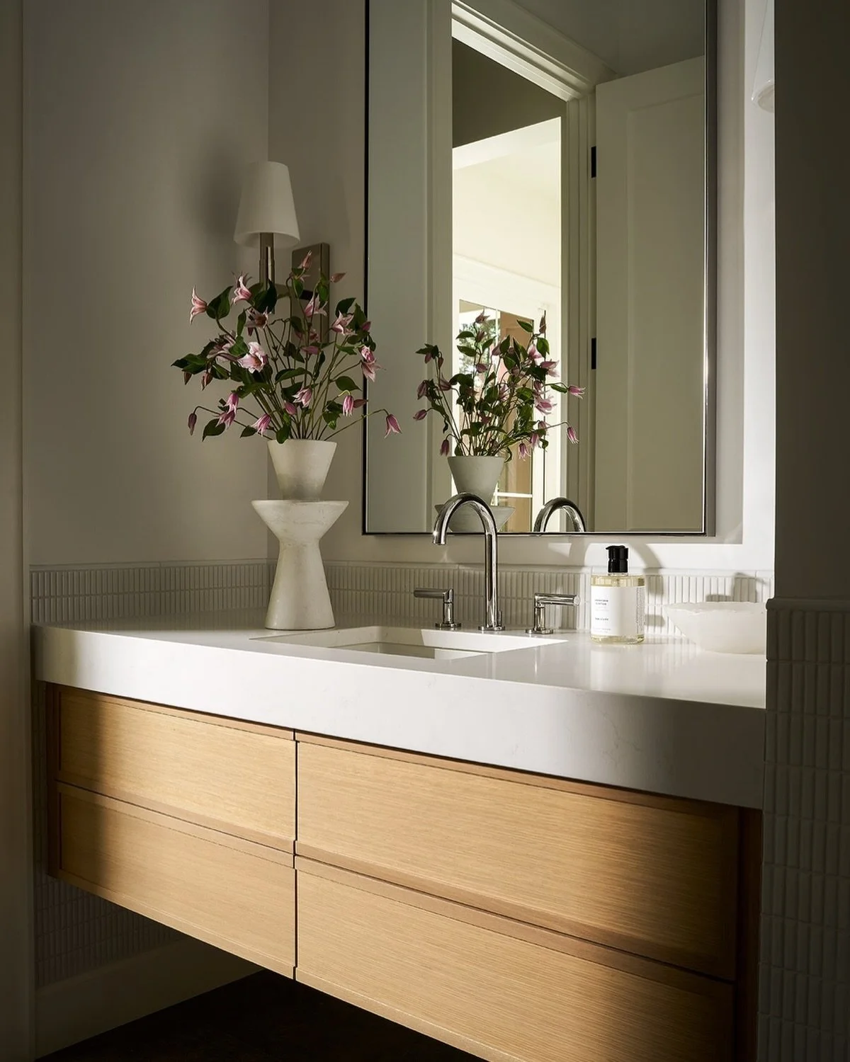What we labeled the pool powder room is located just off the pool and was designed to feel a bit more playful and modern than the rest of the home. A floating vanity, mitered countertops, and fun wall tile create a fresh, clean look while still feeli