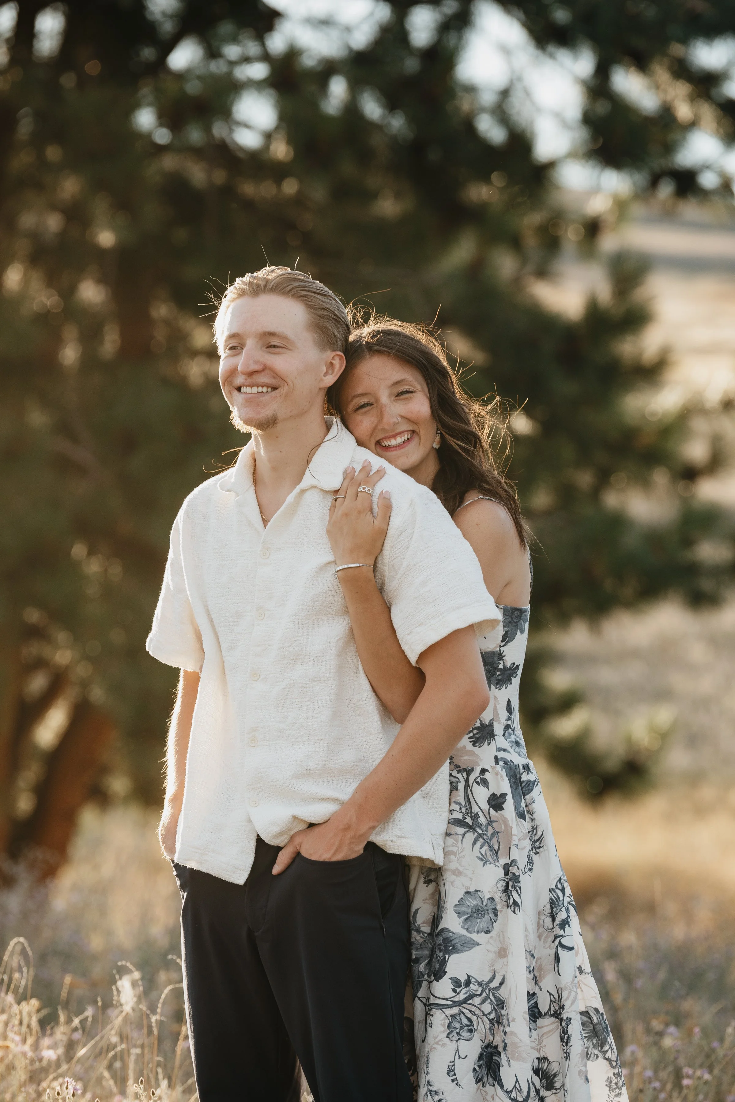 Romantic engagement photography in Montana showcasing big sky views, grassy fields, and genuine connection between couples.