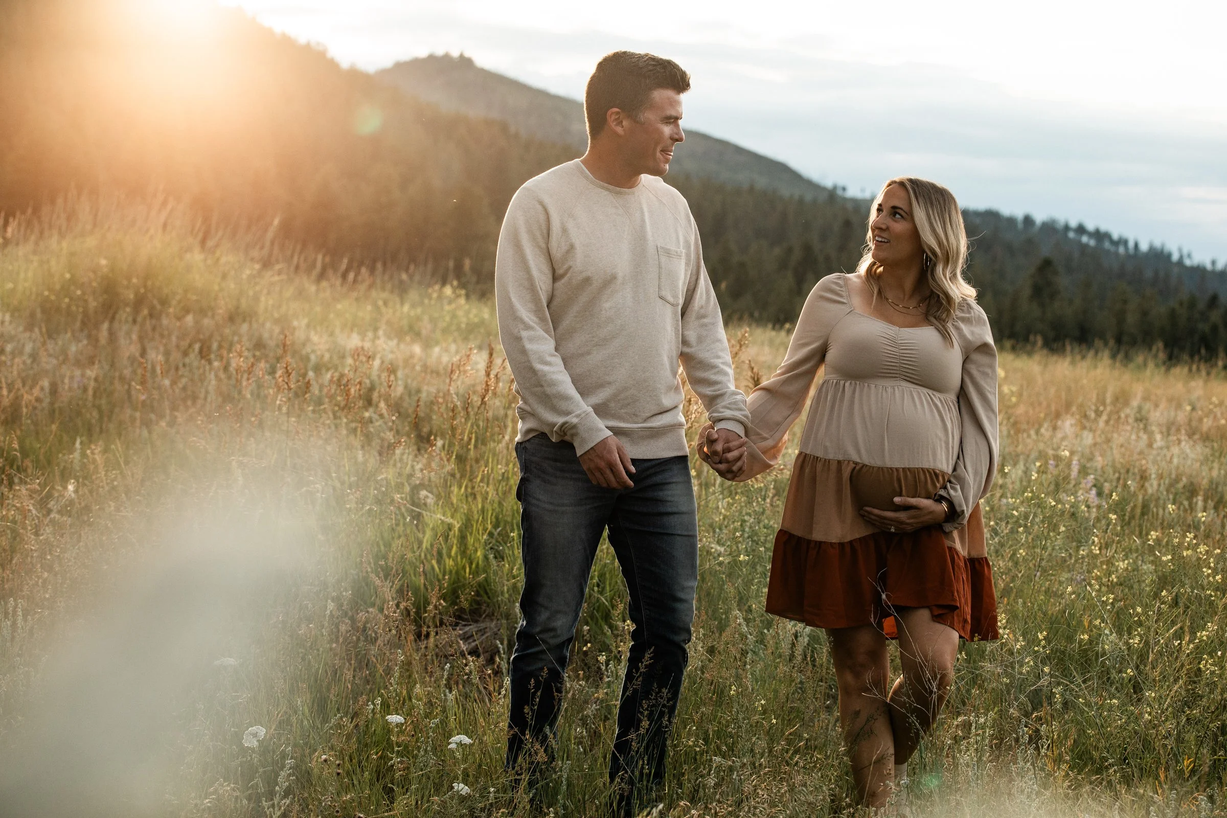 Missoula maternity photographer capturing glowing golden-hour maternity photos in Montana fields with mountain views and soft evening light.