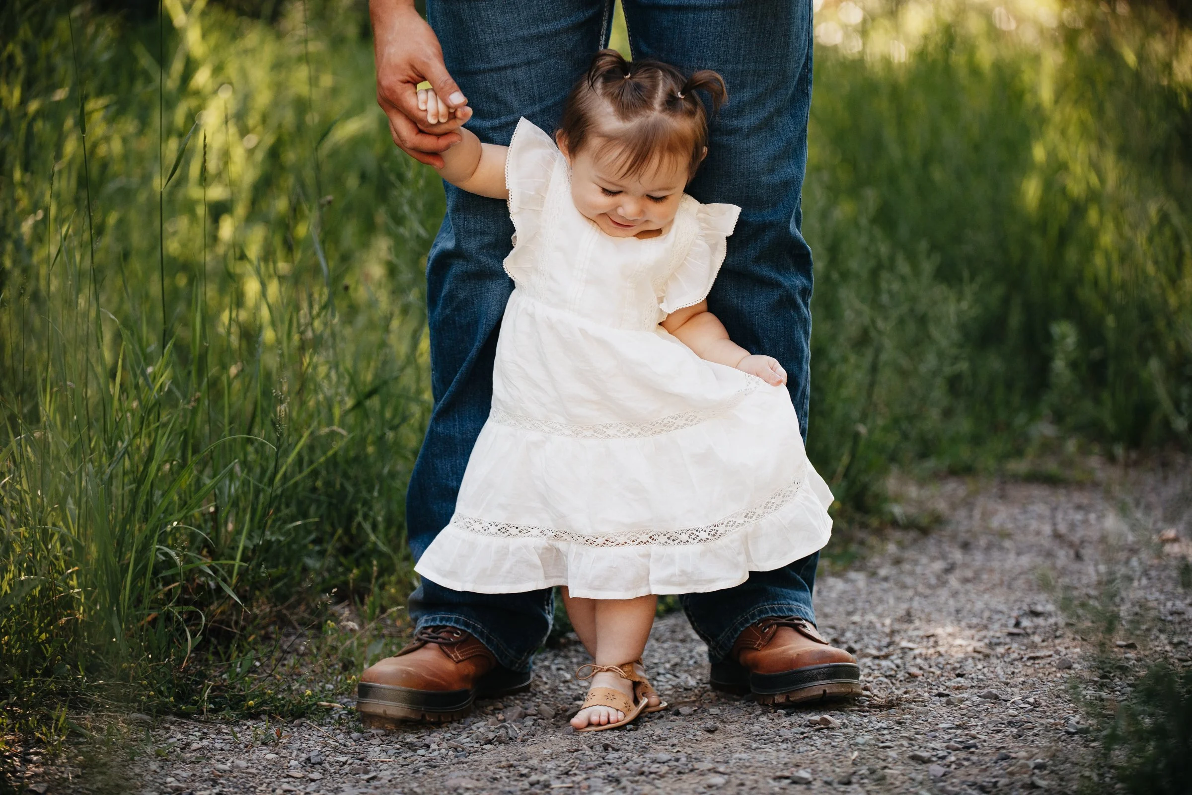 Montana family photographer offering summer family photos in Missoula, highlighting sweet moments between parents and their young daughter outdoors.