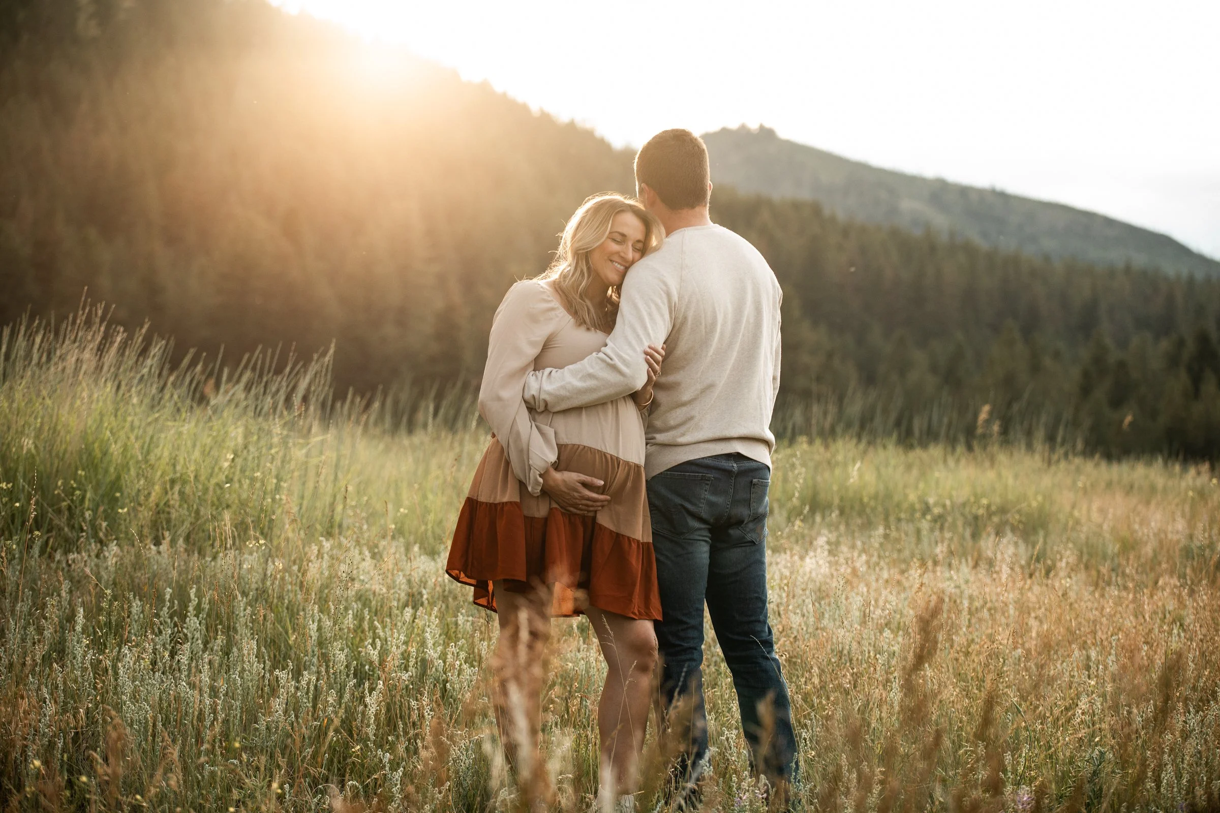 Golden hour maternity photography by a Missoula photographer, highlighting expecting mothers in open Montana fields with scenic mountain backdrops.