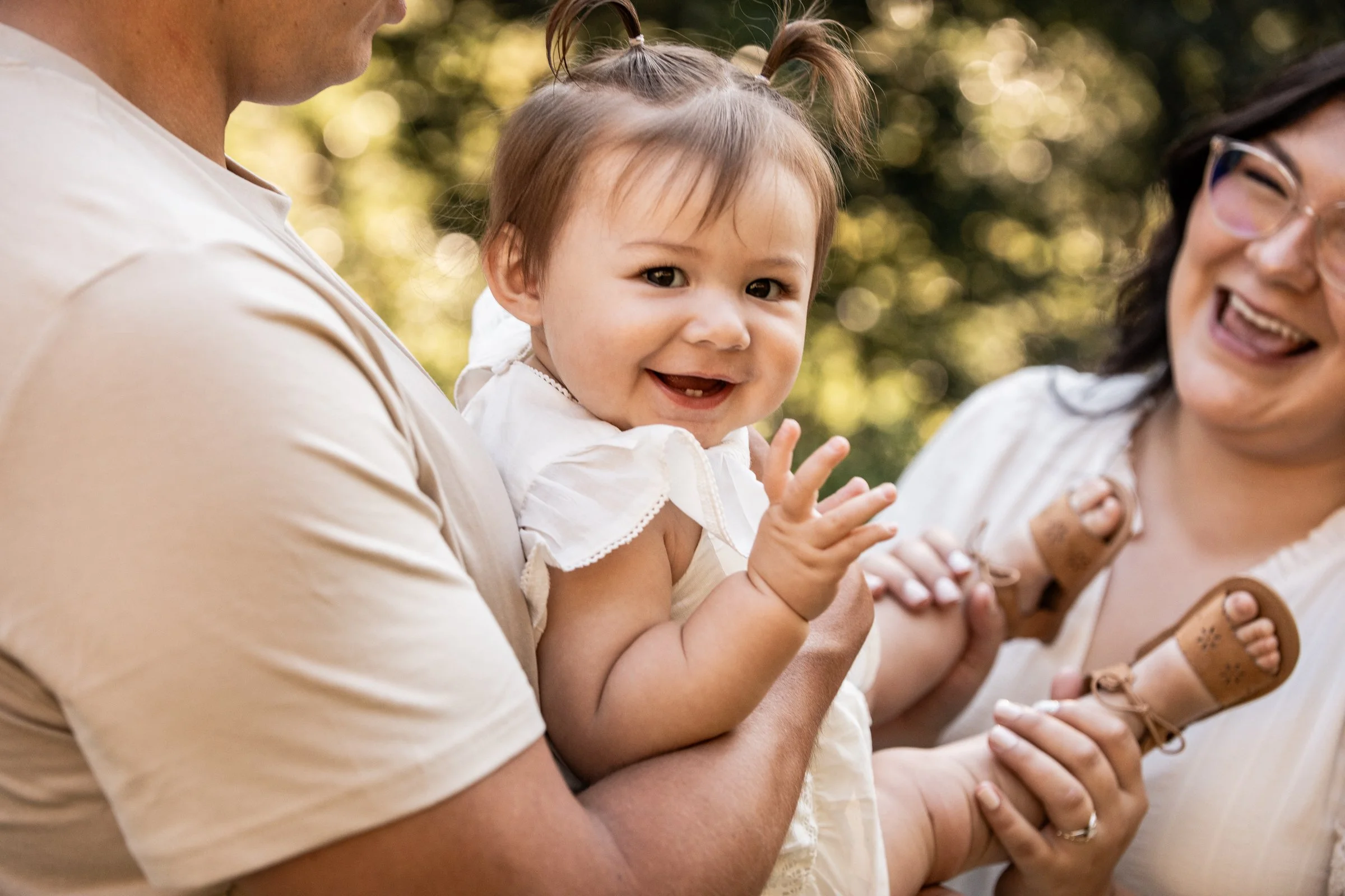 Summer family photography by a Missoula photographer, focusing on joyful, candid moments with a mom, dad, and little girl in natural Montana light.
