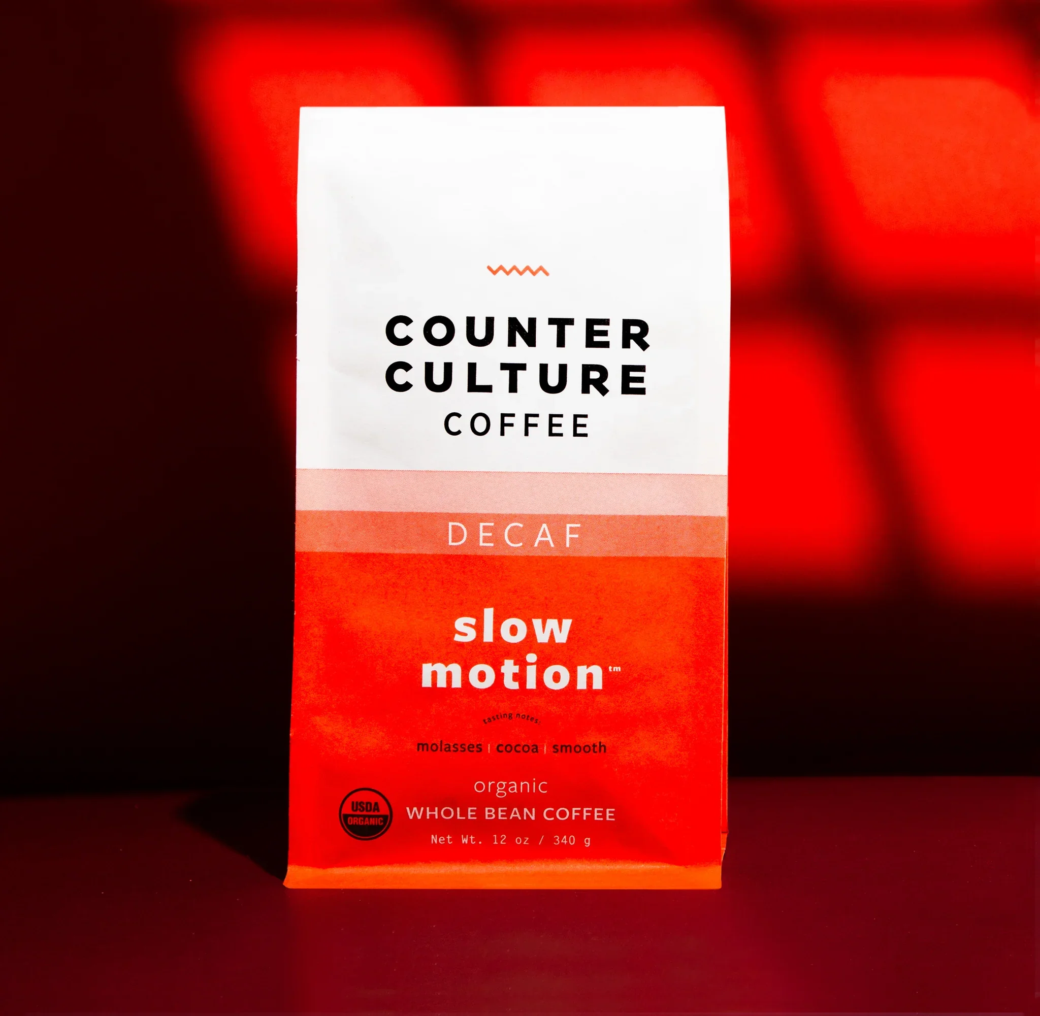 Counter Culture Coffee Slow Motion decaf packaging — red orange gradient organic whole bean coffee bag