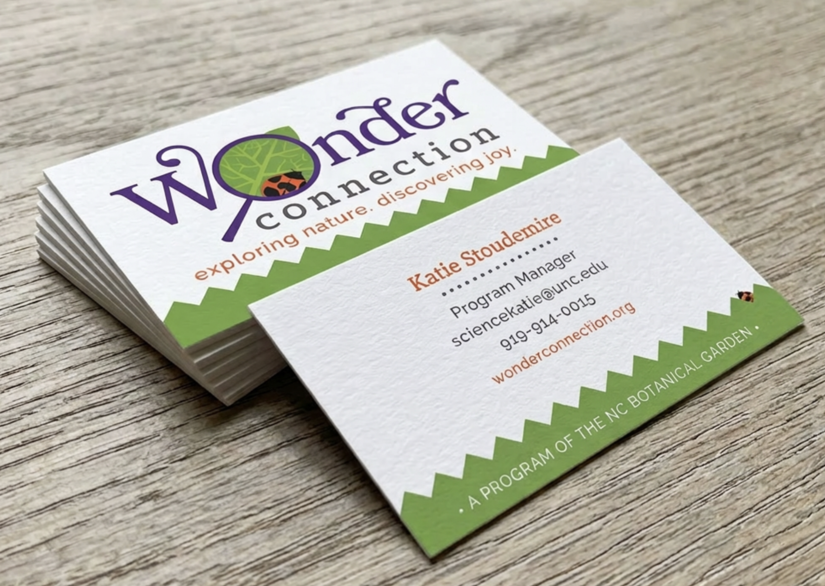 Wonder Connection business cards — white and green cards with logo exploring nature discovering joy tagline