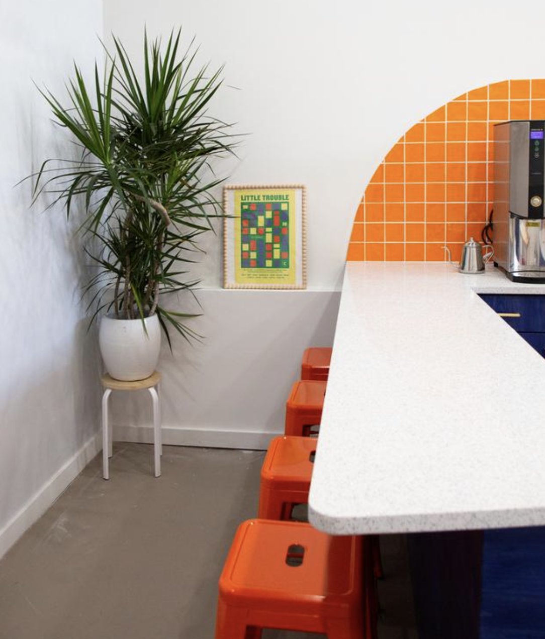 Counter Culture Coffee Atlanta Training Center corner detail — orange quarter circle tile with navy counter and orange stools