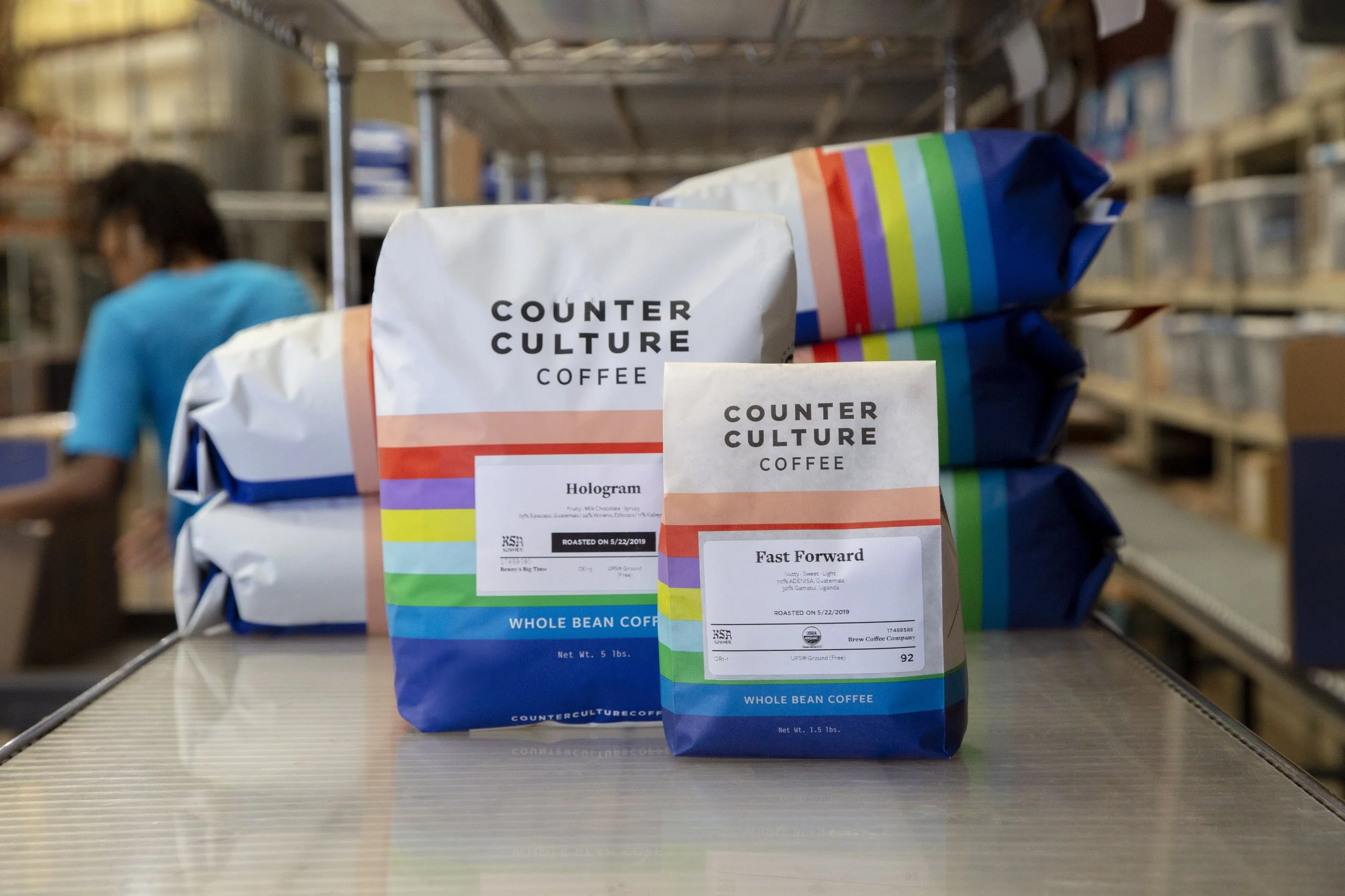 Counter Culture Coffee bulk 5lb and 1.5lb packaging redesign — multicolor stripe whole bean coffee bags in warehouse