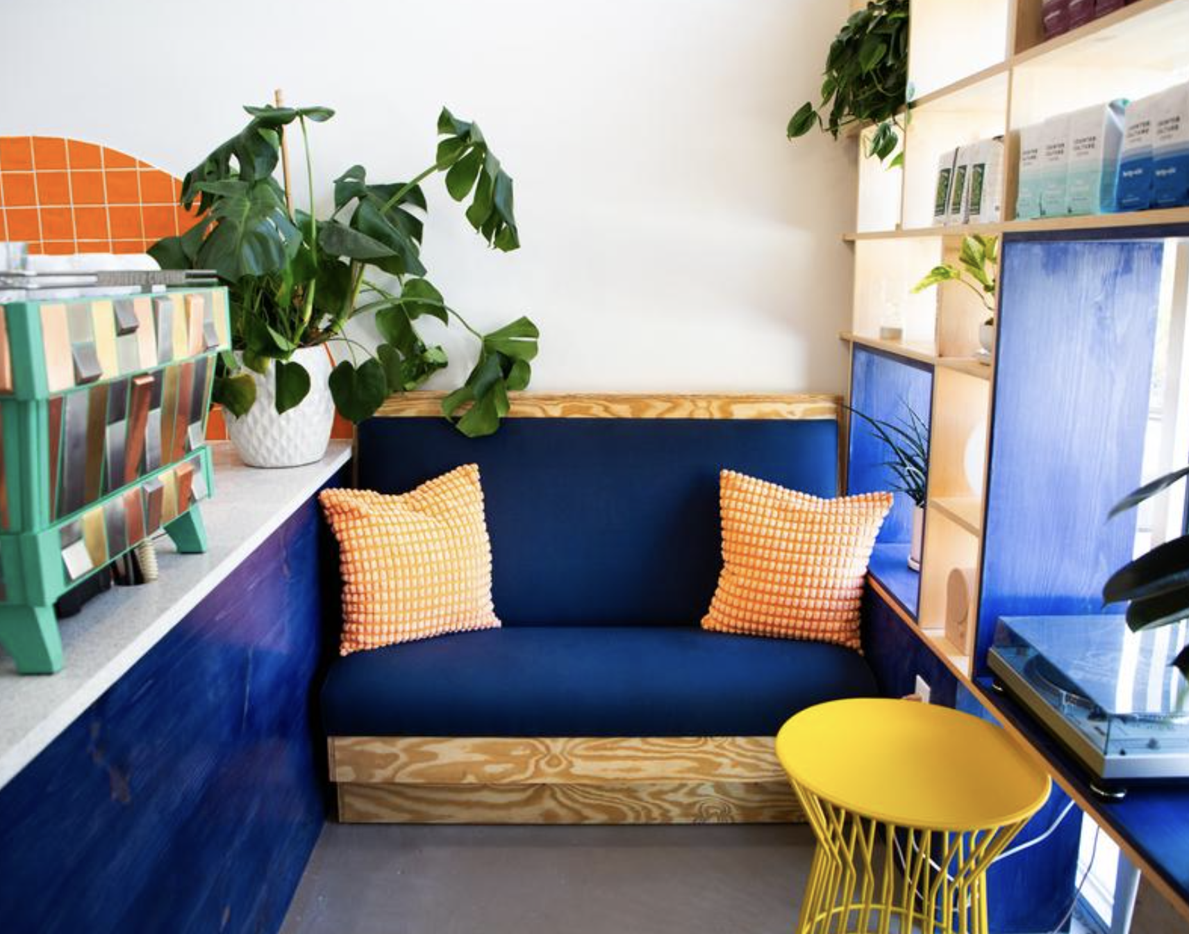 Counter Culture Coffee Atlanta Training Center seating nook — navy banquette with orange cushions and yellow side table