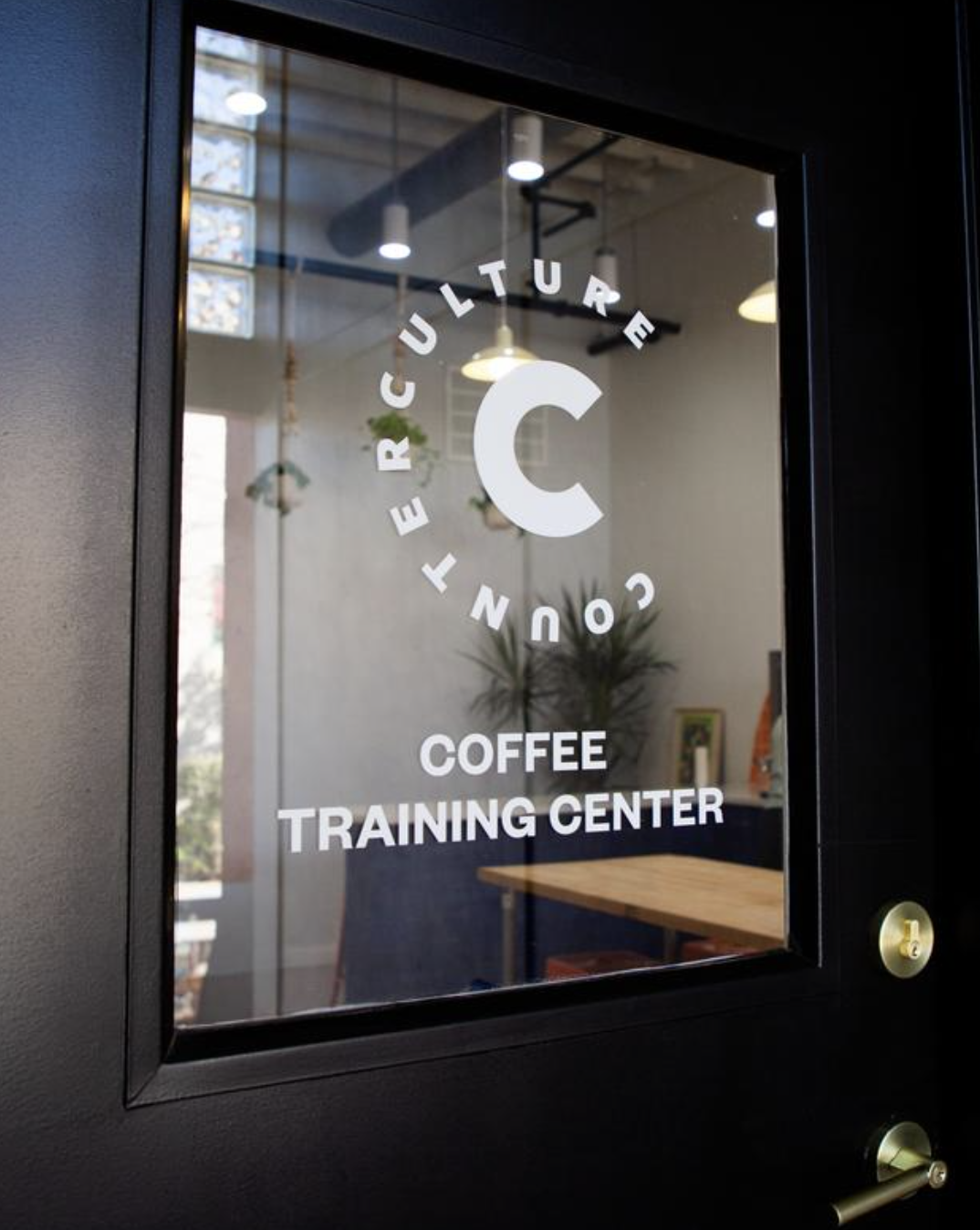 Counter Culture Coffee Training Center glass door signage — white logo on dark glass