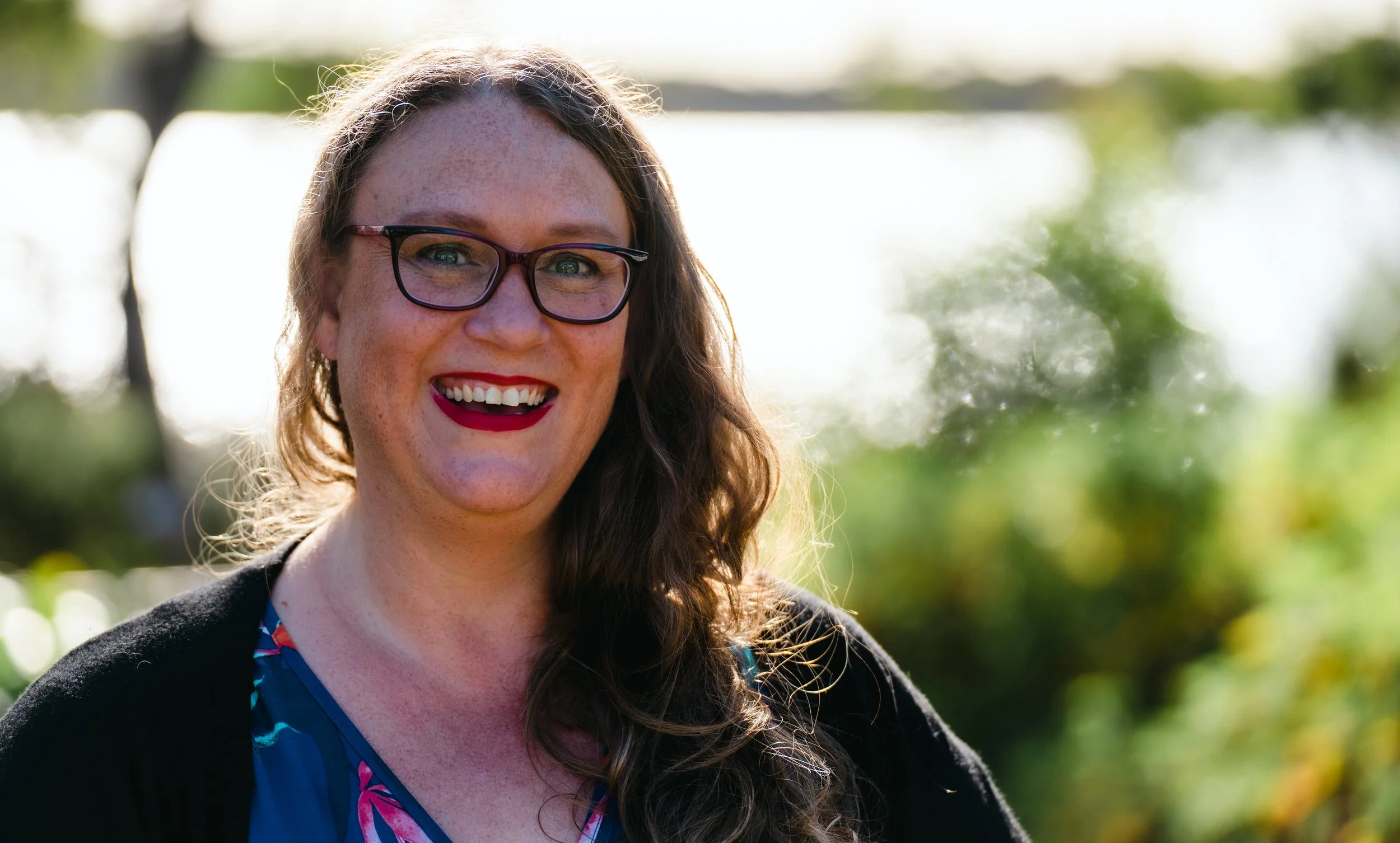 PICTURE OF ARTIST CHRISTIE LANGE SMILING IN FRONT OF GRANTS LAGOON BINALONG BAY TASMANIA