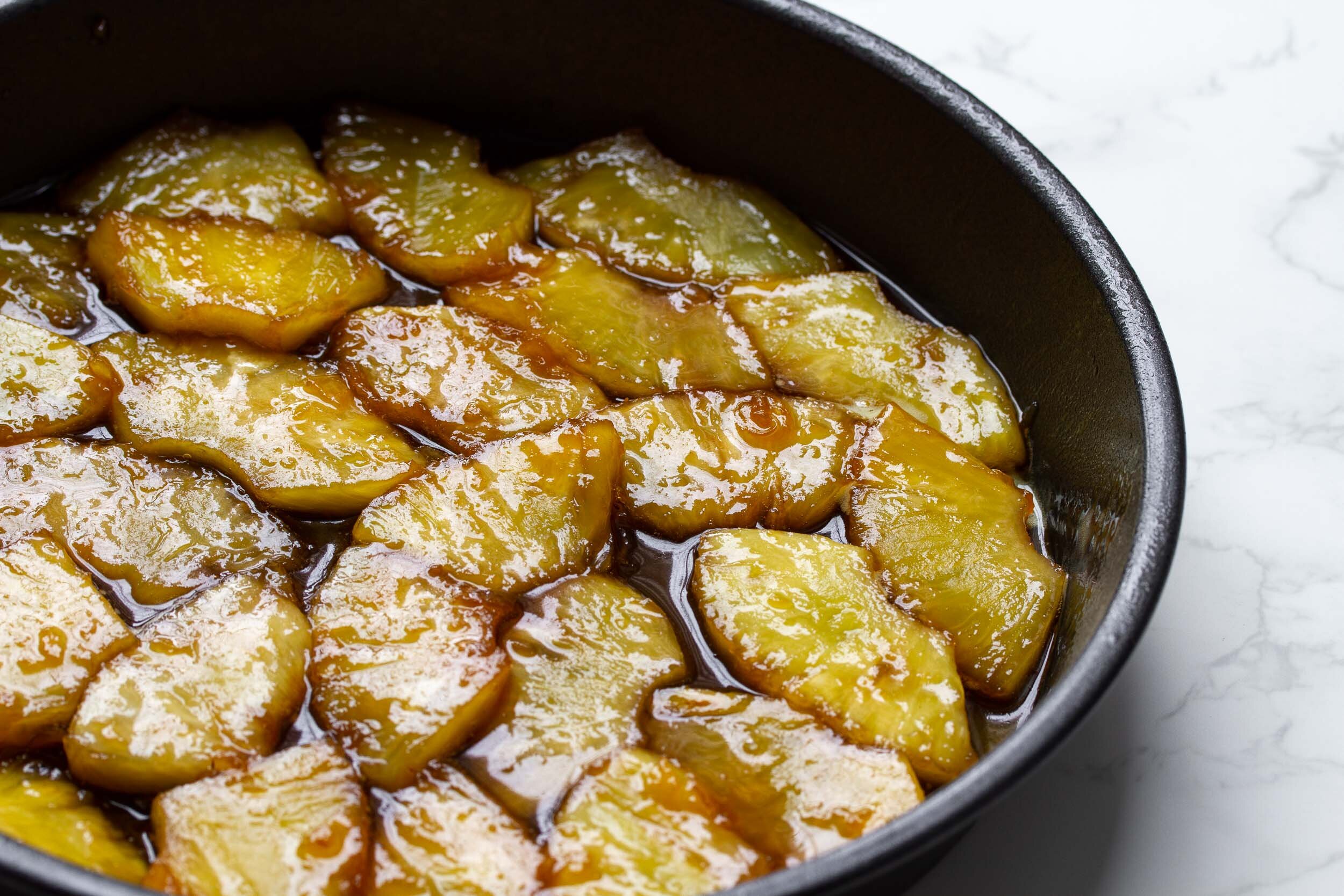  Put the fruit with the syrup into a single layer in the cake pan. 