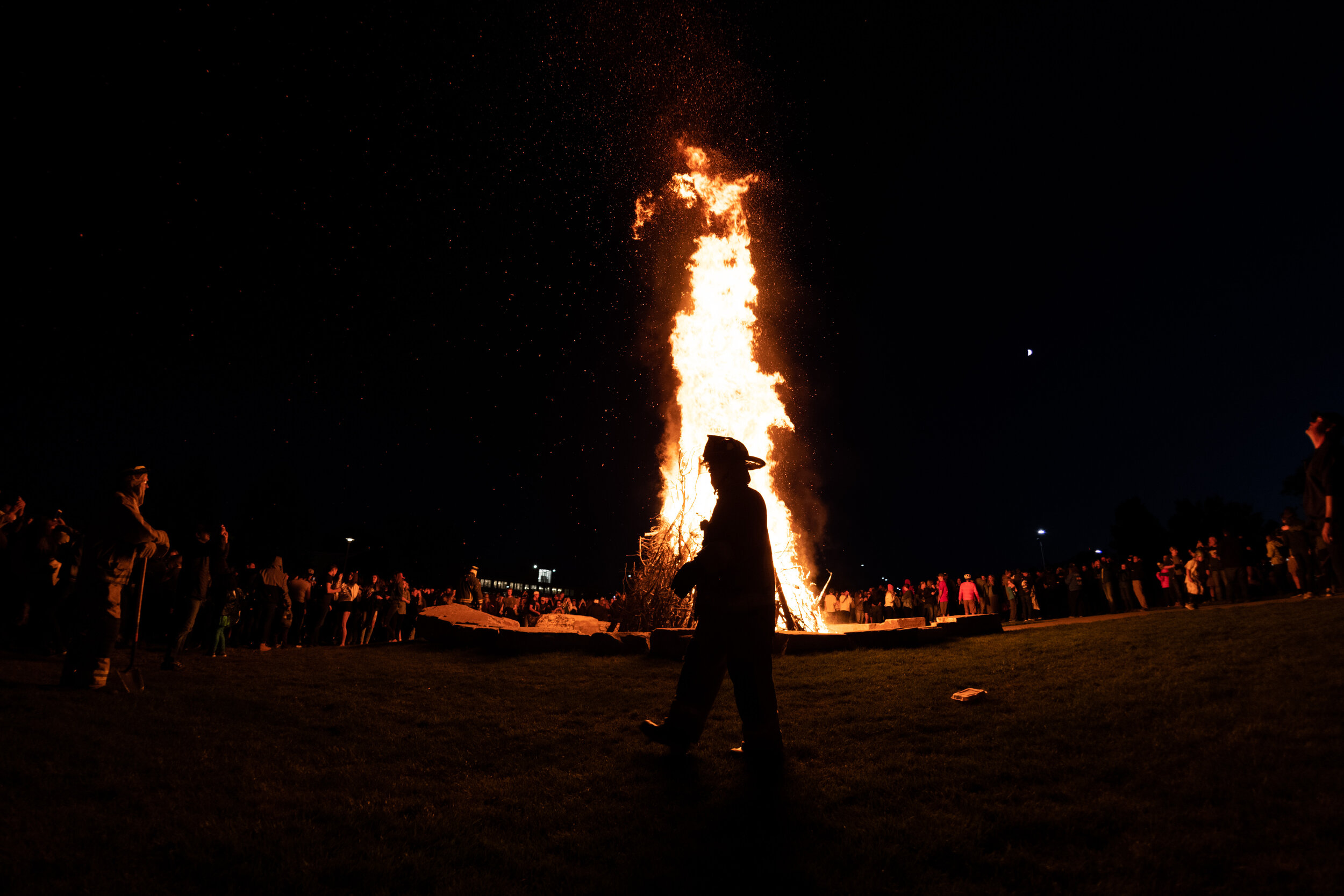 A firefighter tends to the bonfire during the Colorado State University Homecoming celebration on Oct. 4, 2019. (Colin Shepherd | The Rocky Mountain Collegian)