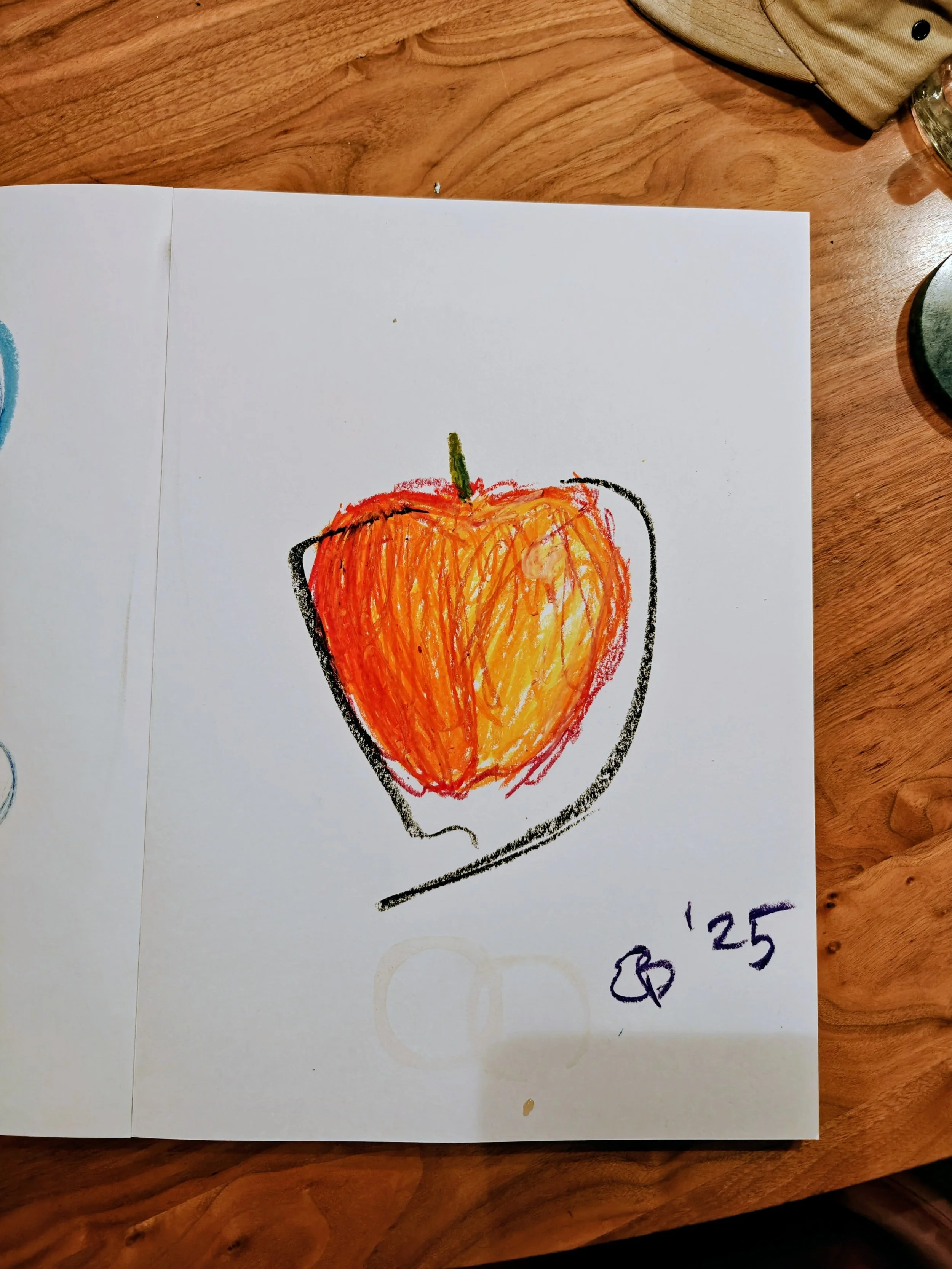 Colorful drawing of a left half of a bell pepper with a green stem, with red, orange, and yellow crayon strokes, surrounded by a black outline on white paper. There are handwritten numbers and a small drawing of a ring at the bottom right corner.