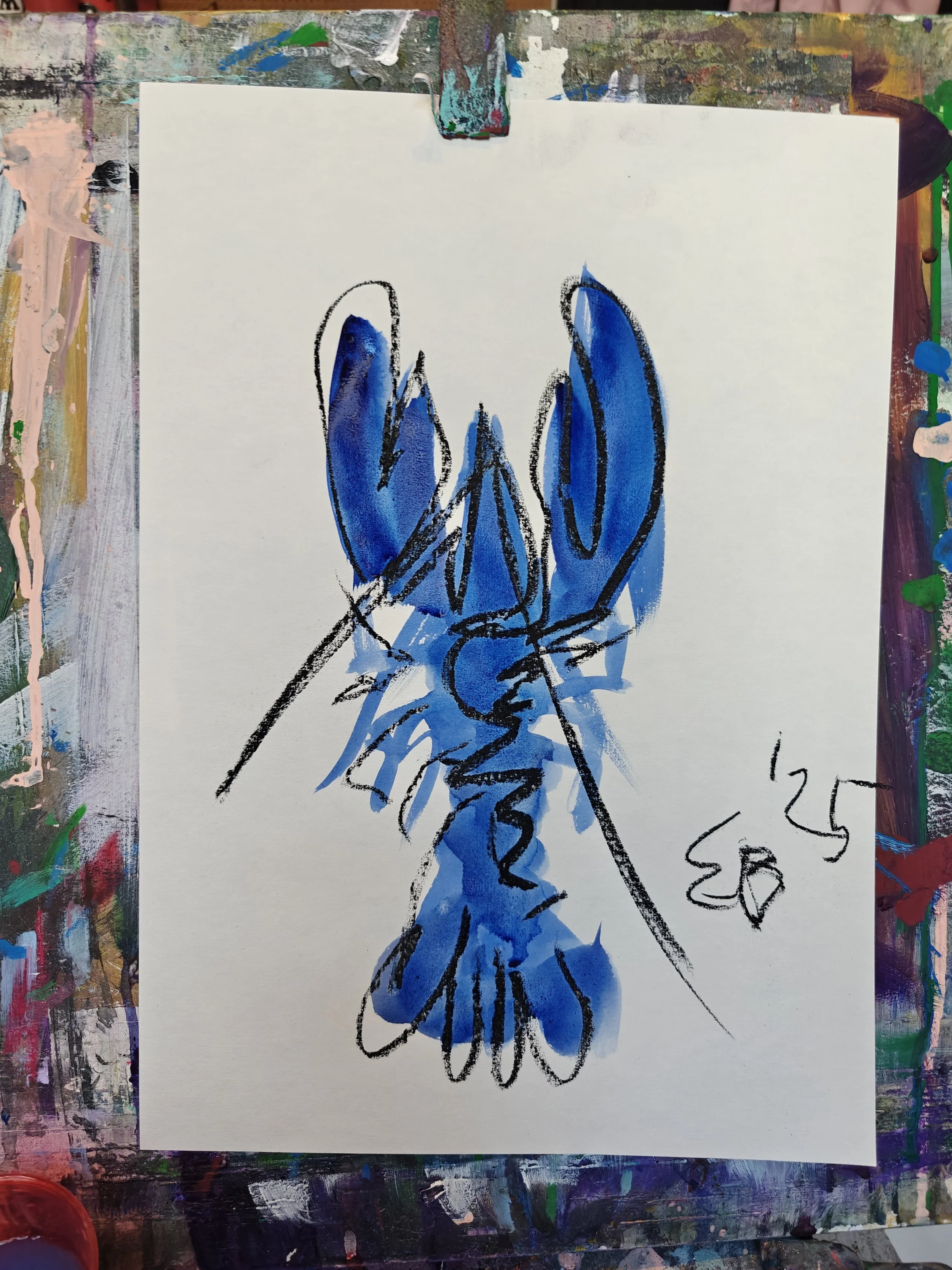 An abstract painting of a blue lobster or crayfish, signed with the date '25' on a white sheet, surrounded by an artist's multicolored, textured canvas surface.