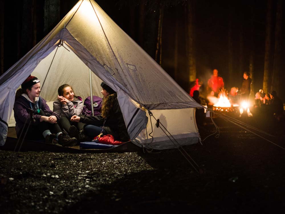 three-female-cubs-in-tent-with-campfire-jpg.jpg