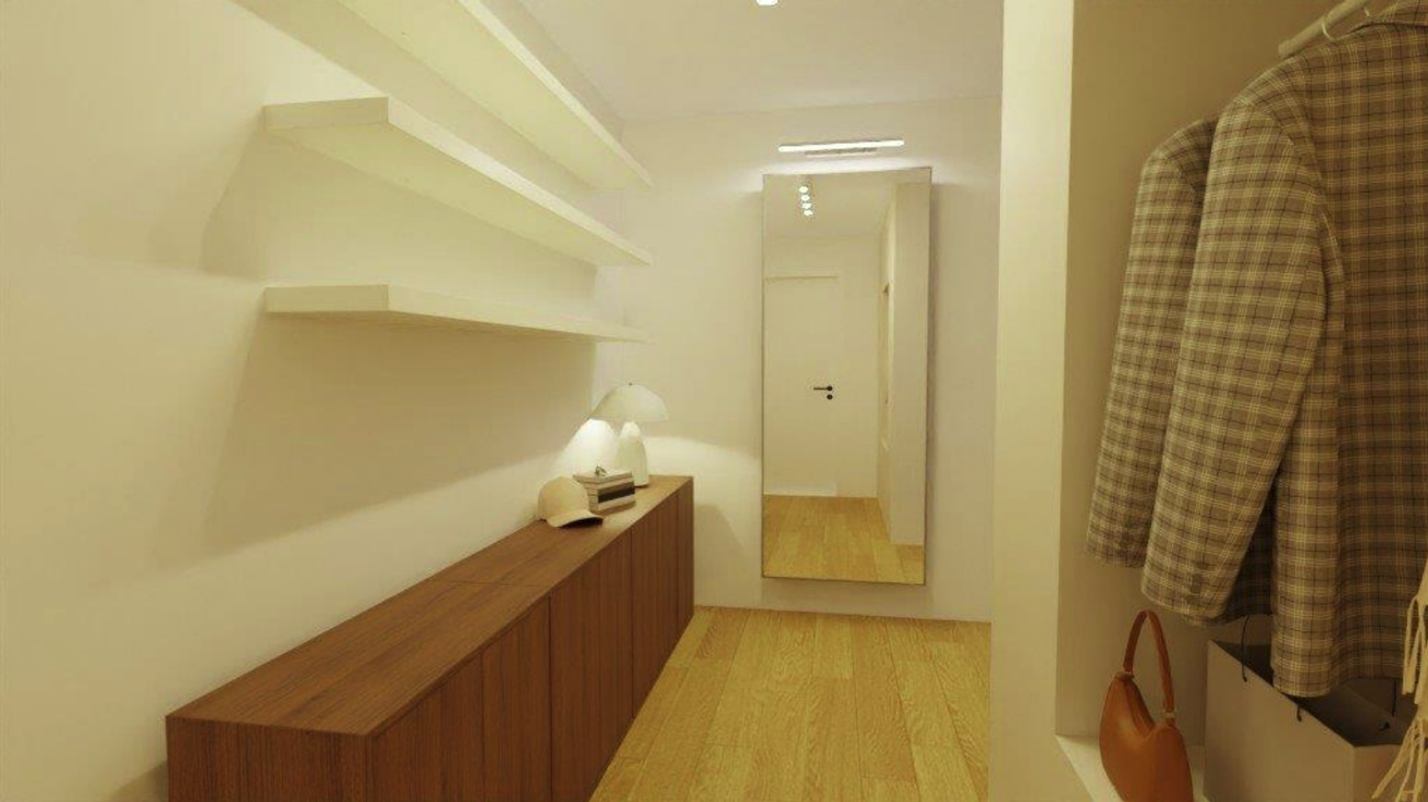 A narrow entryway with a large mirror on the wall, a white shelf with a lamp and hats, a wooden console beneath, and a clothing rack with checkered jackets and a leather bag.