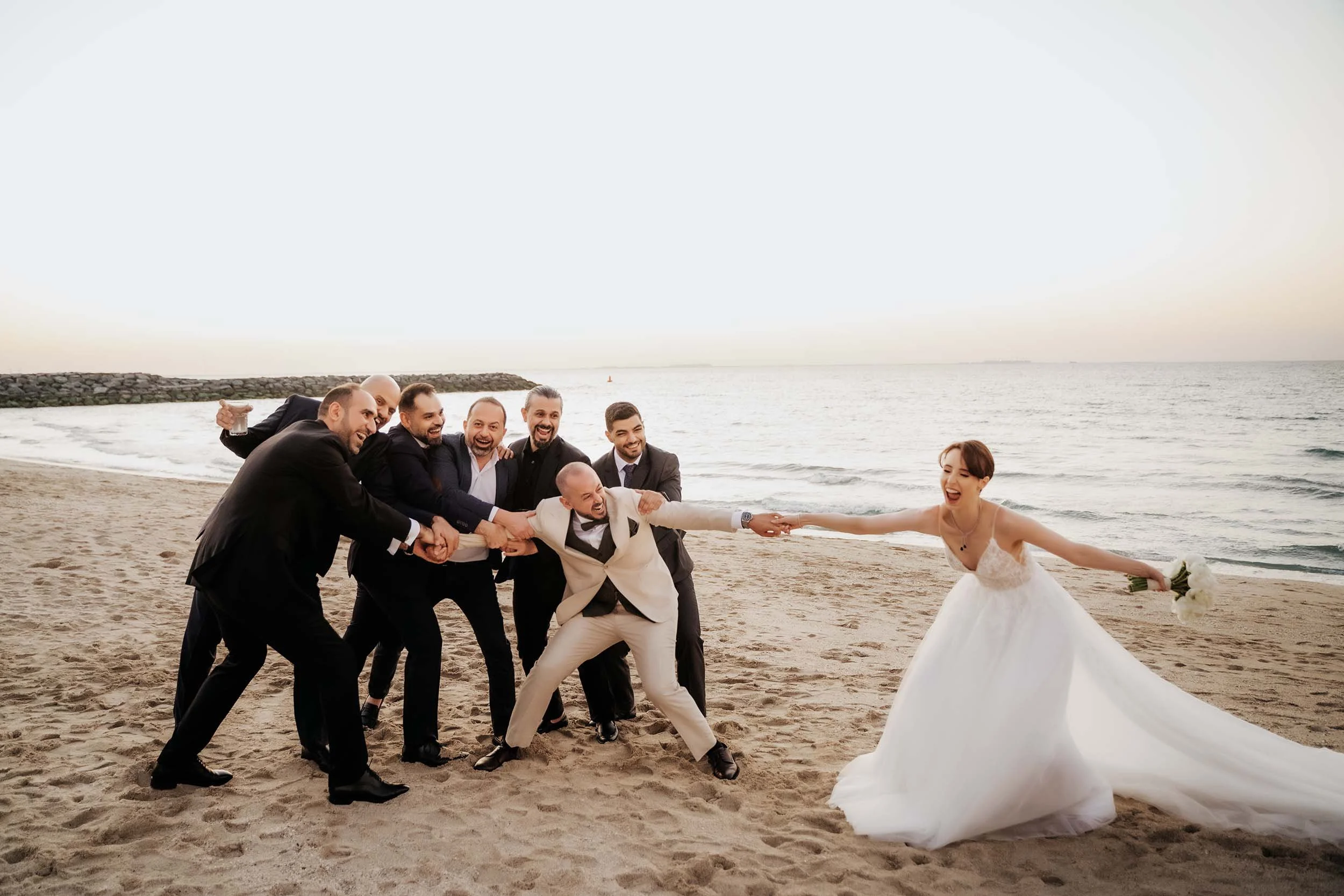 Fun group wedding photo in Dubai with bride, groom and friends celebrating together