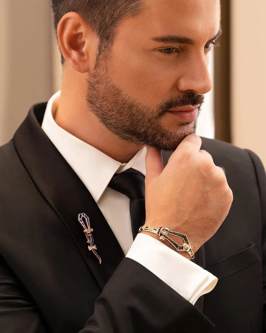 Men's luxury bracelet and lapel pin jewelry styled with formal suit