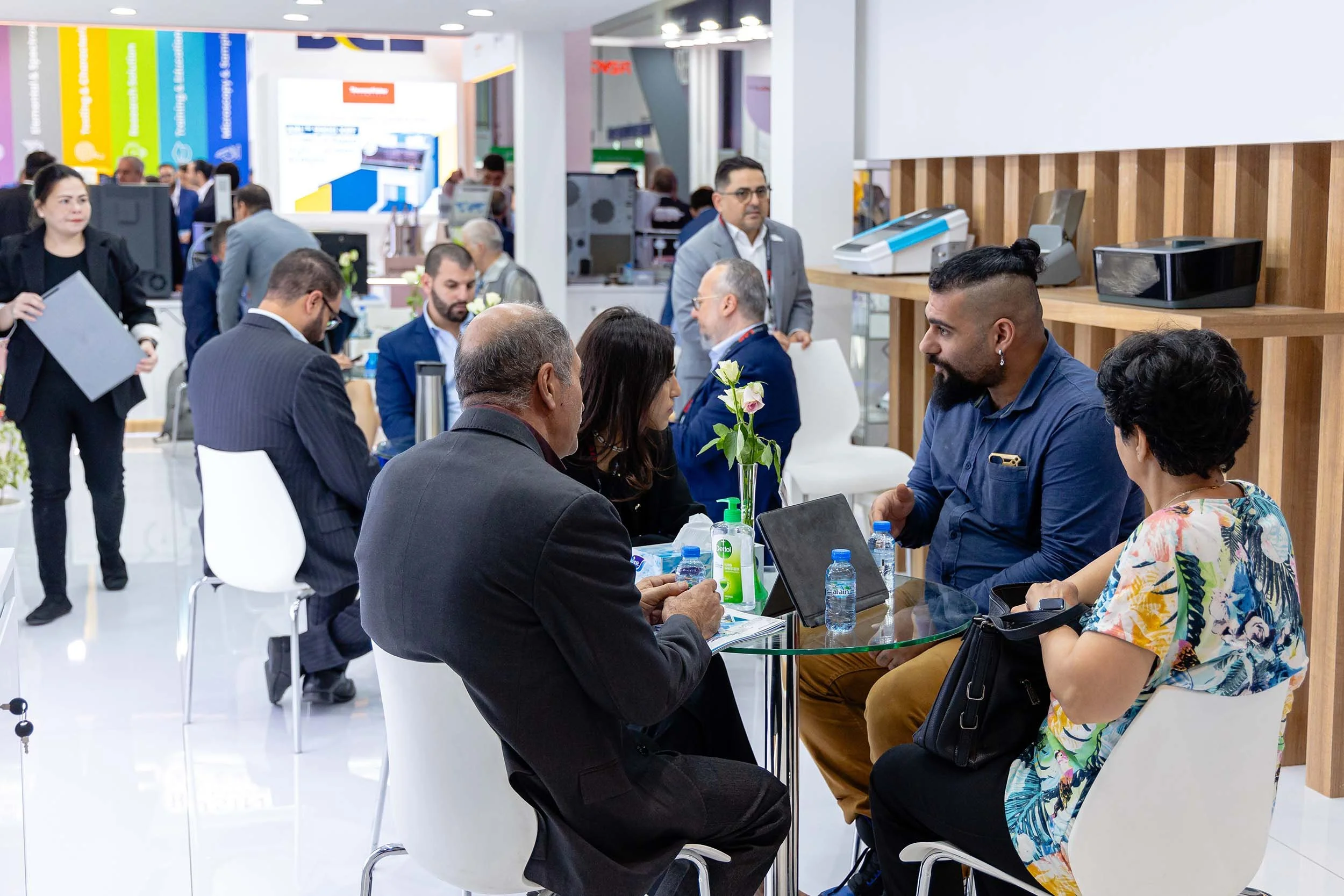 Business meeting with clients inside the Gulf Scientific exhibition stand during a laboratory and healthcare exhibition in Dubai.