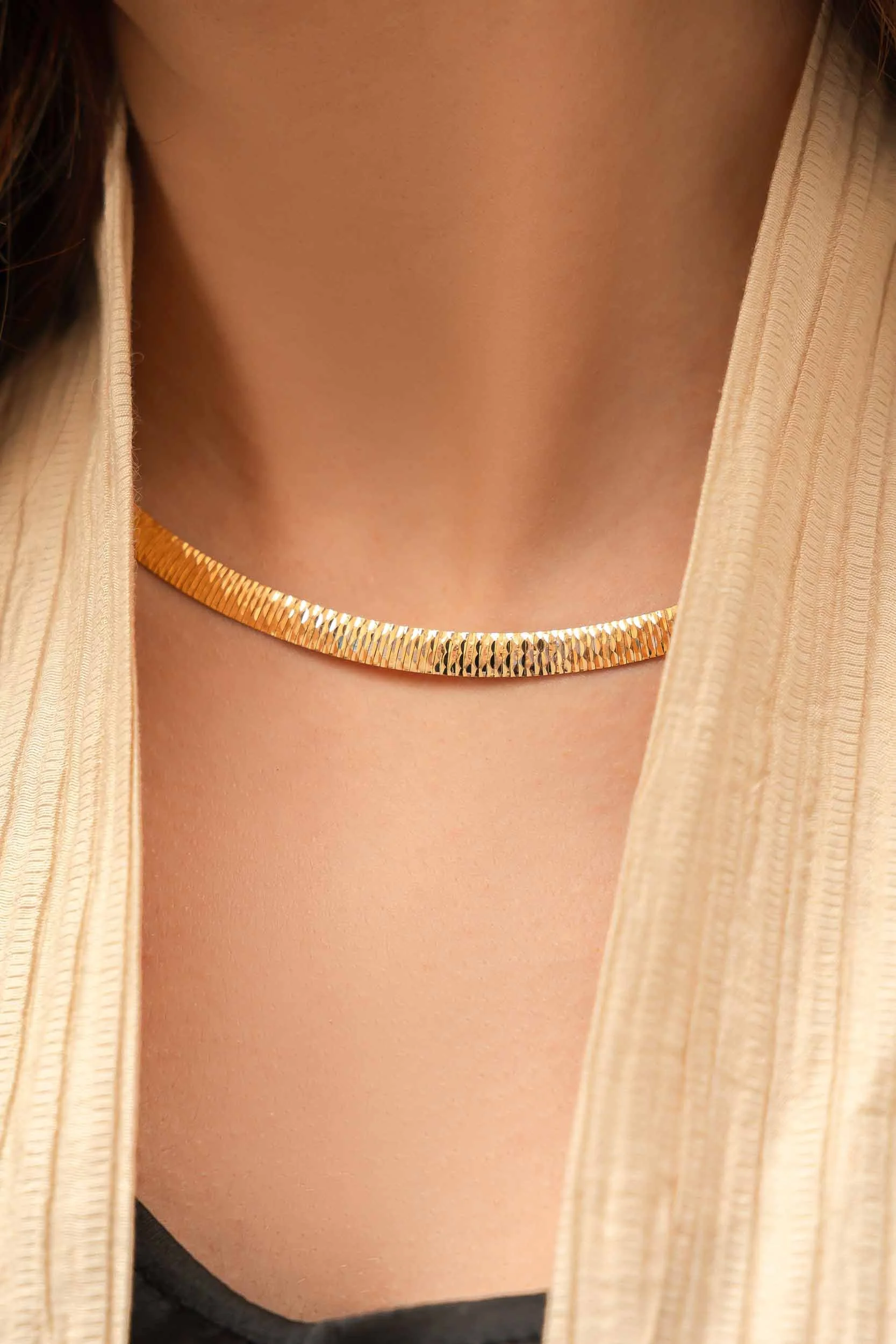 Gold herringbone necklace close-up luxury jewelry photography