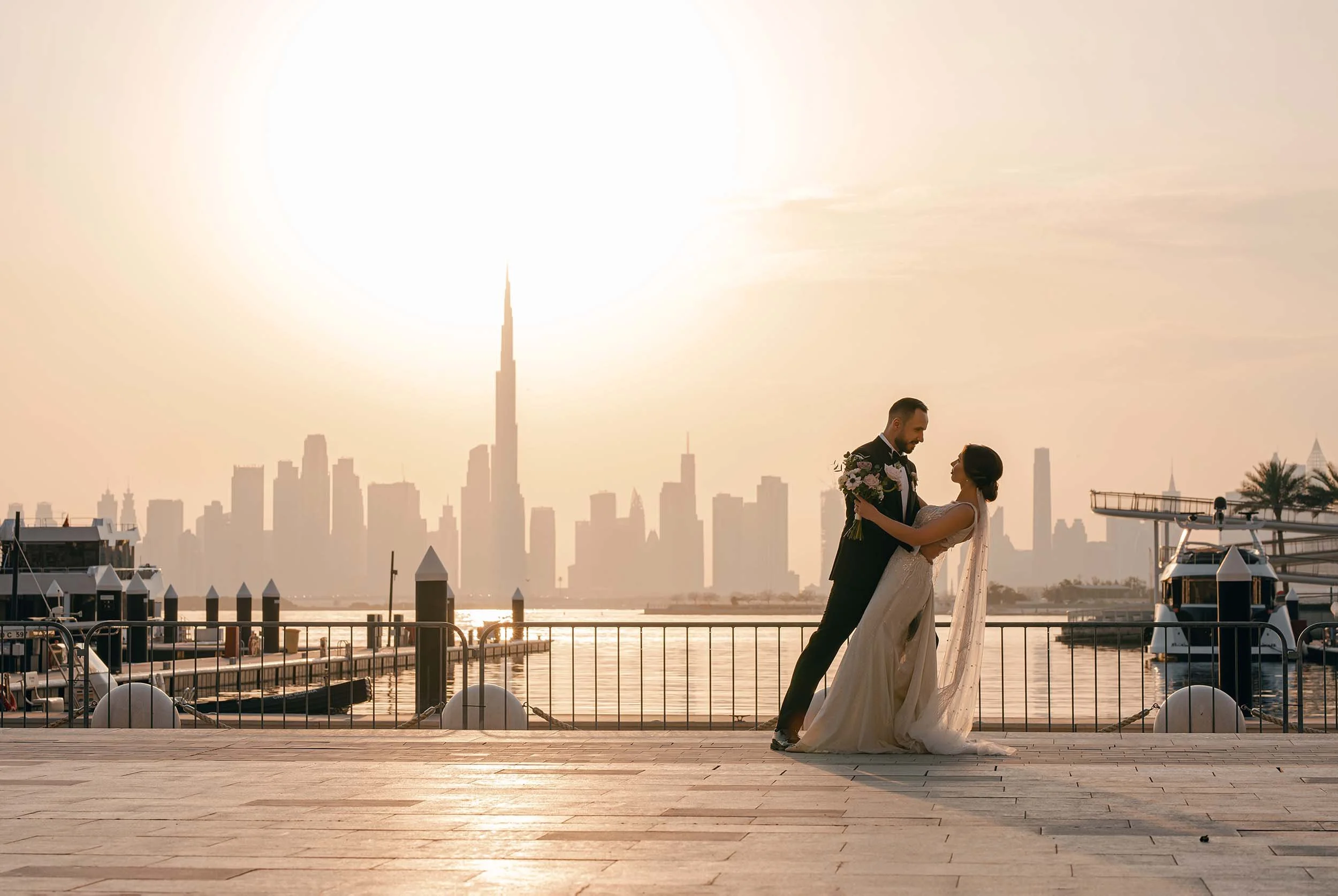 Luxury wedding photography and videography in Dubai capturing a couple during a golden-hour waterfront portrait.