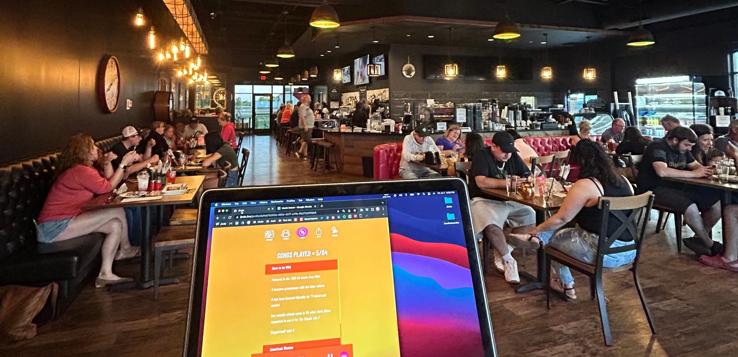Host's laptop running the Jindo Jam Deck dashboard overlooking a packed dueling brews restaurant venue during a live music bingo event becker mn.