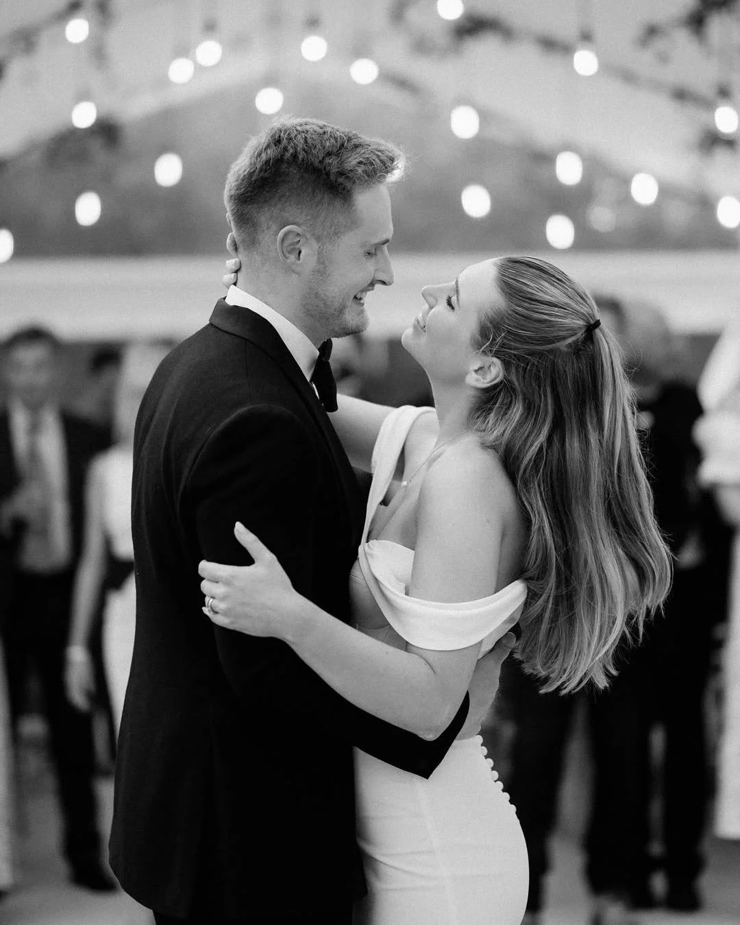 Luxury wedding first dance with couple under soft lighting and guests in the background